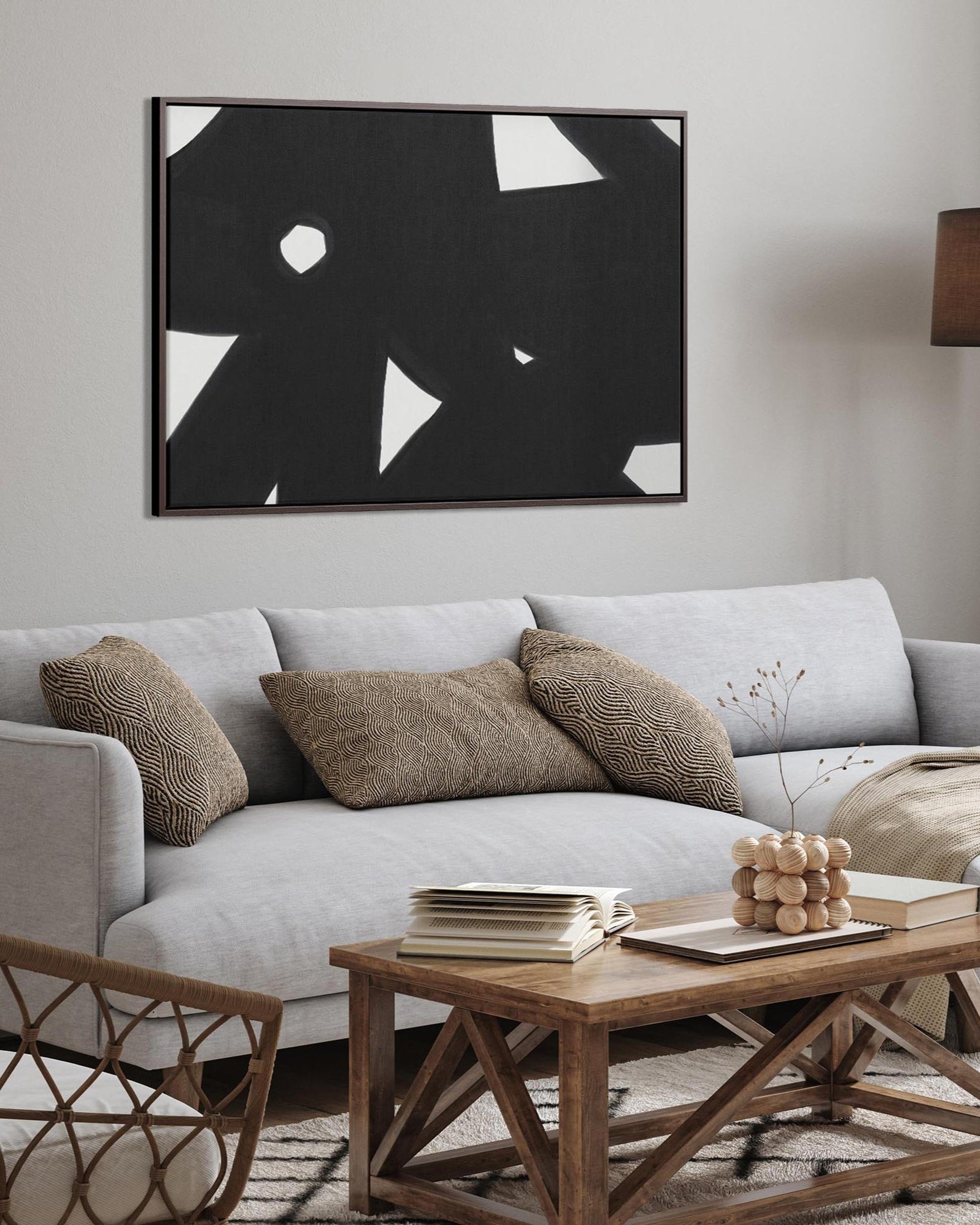Modern living room with a gray sofa, wooden coffee table, and abstract art on the wall.