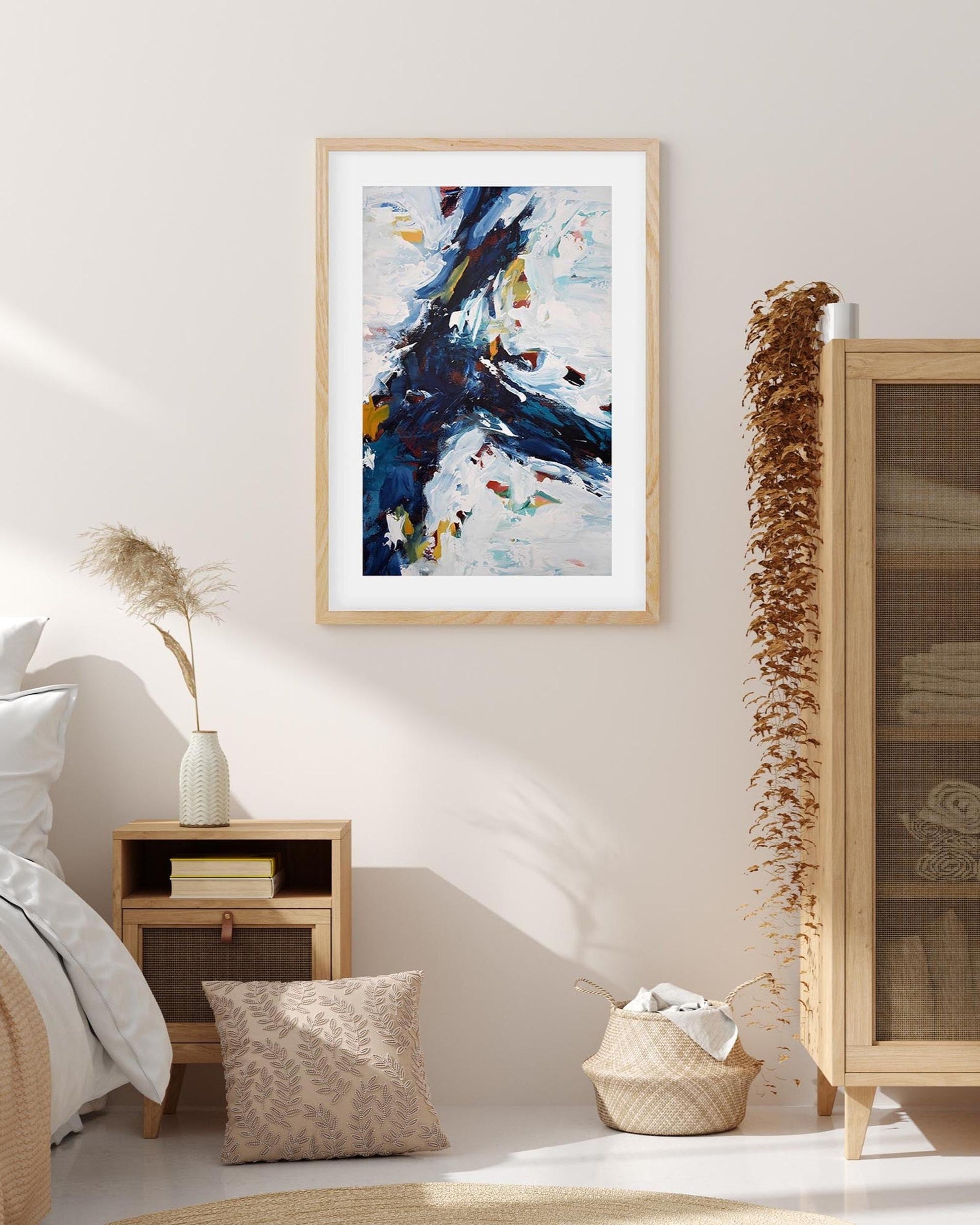 Framed abstract art piece on a wall in a bedroom setting.