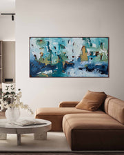 Abstract painting on a wall above a beige sofa in a living room.