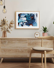 Room interior with wooden sideboard, chair, abstract art, and plants.