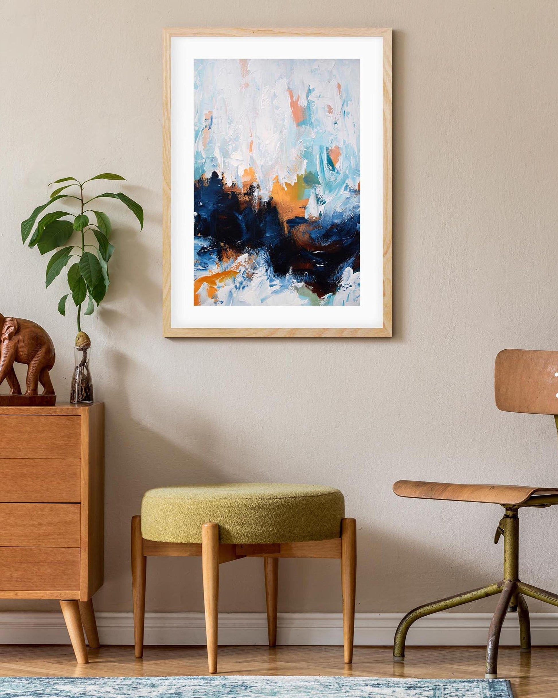 Room interior with a wooden dresser, abstract art, and a chair.