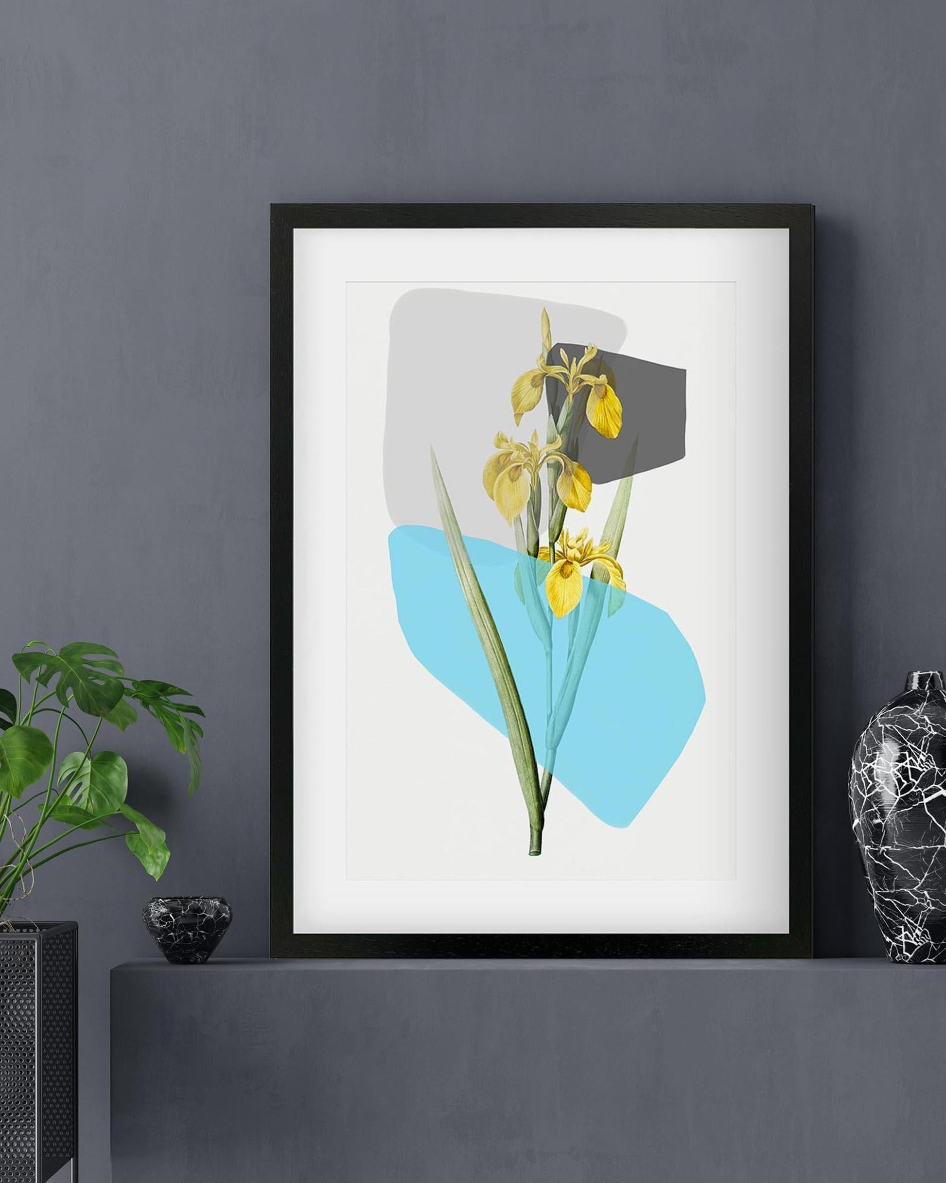 Framed artwork with abstract design of yellow flowers and blue shapes on a gray wall.