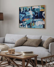 Living room with a gray sofa, wooden coffee table, and abstract painting on the wall.