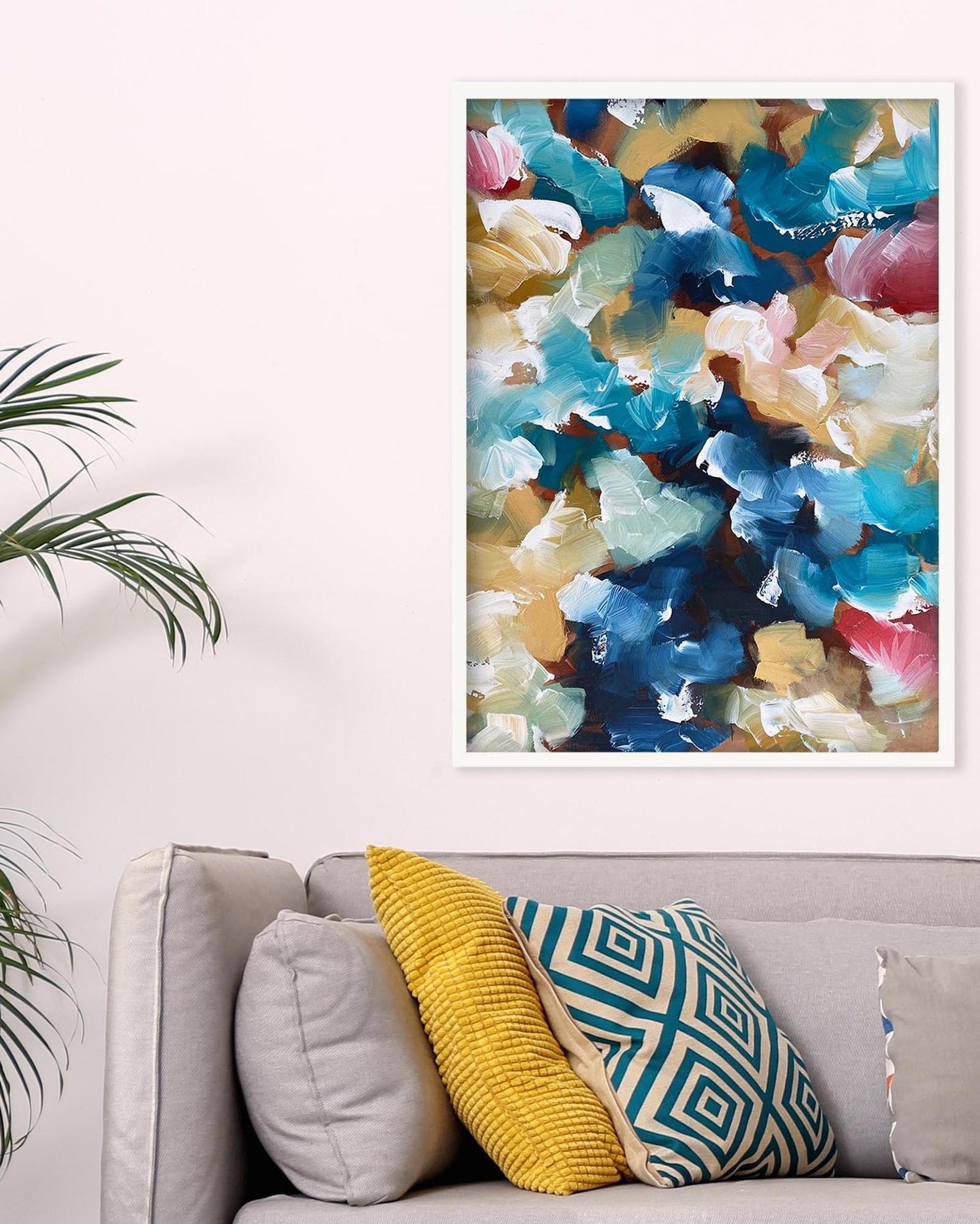 Colorful abstract art print on a wall above a sofa with patterned cushions.