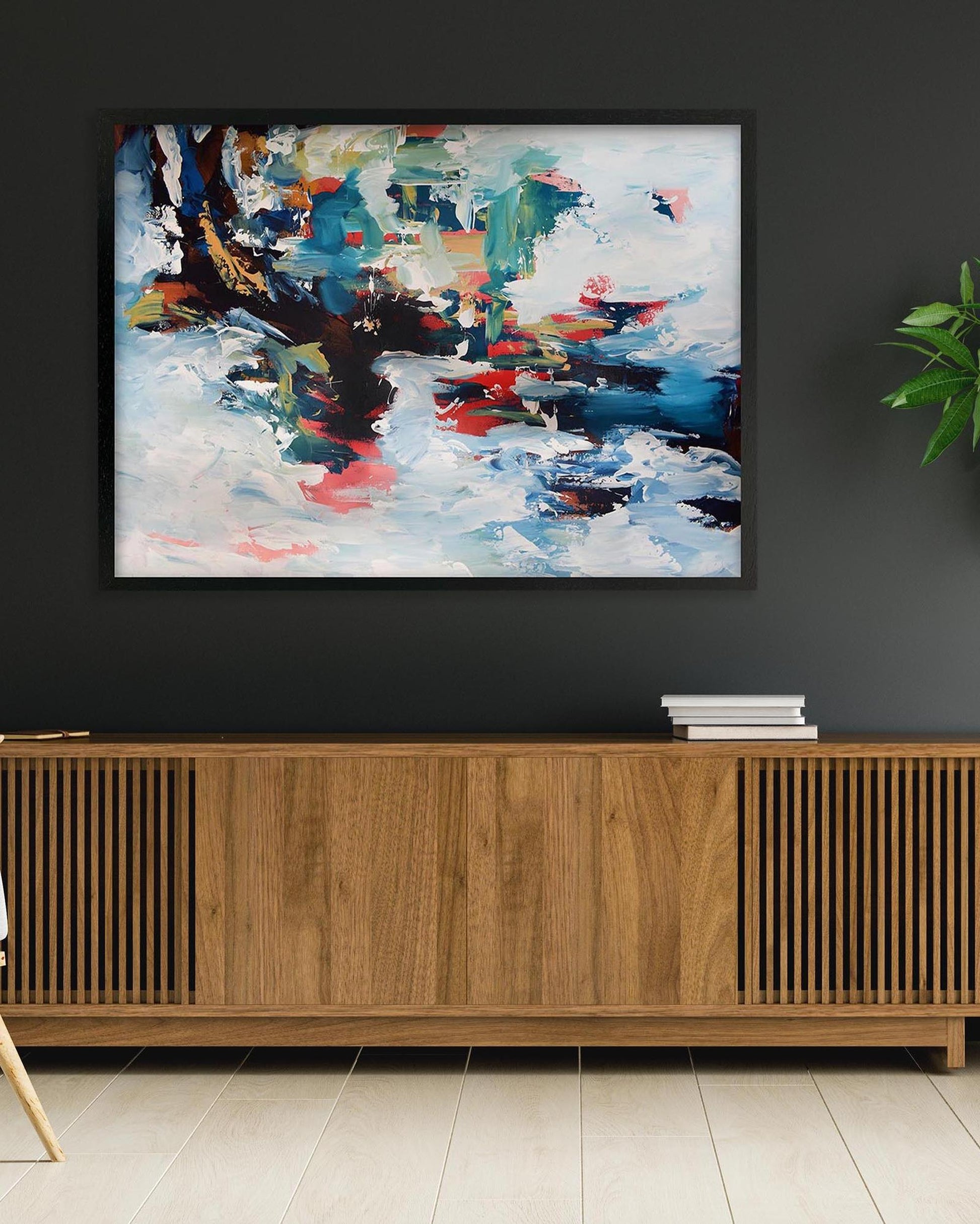Abstract painting on a dark wall above a wooden cabinet