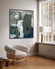 Modern living room with abstract painting on the wall and a white armchair.