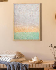 Abstract art piece on a wall above a wooden table with a teapot and decorative items.