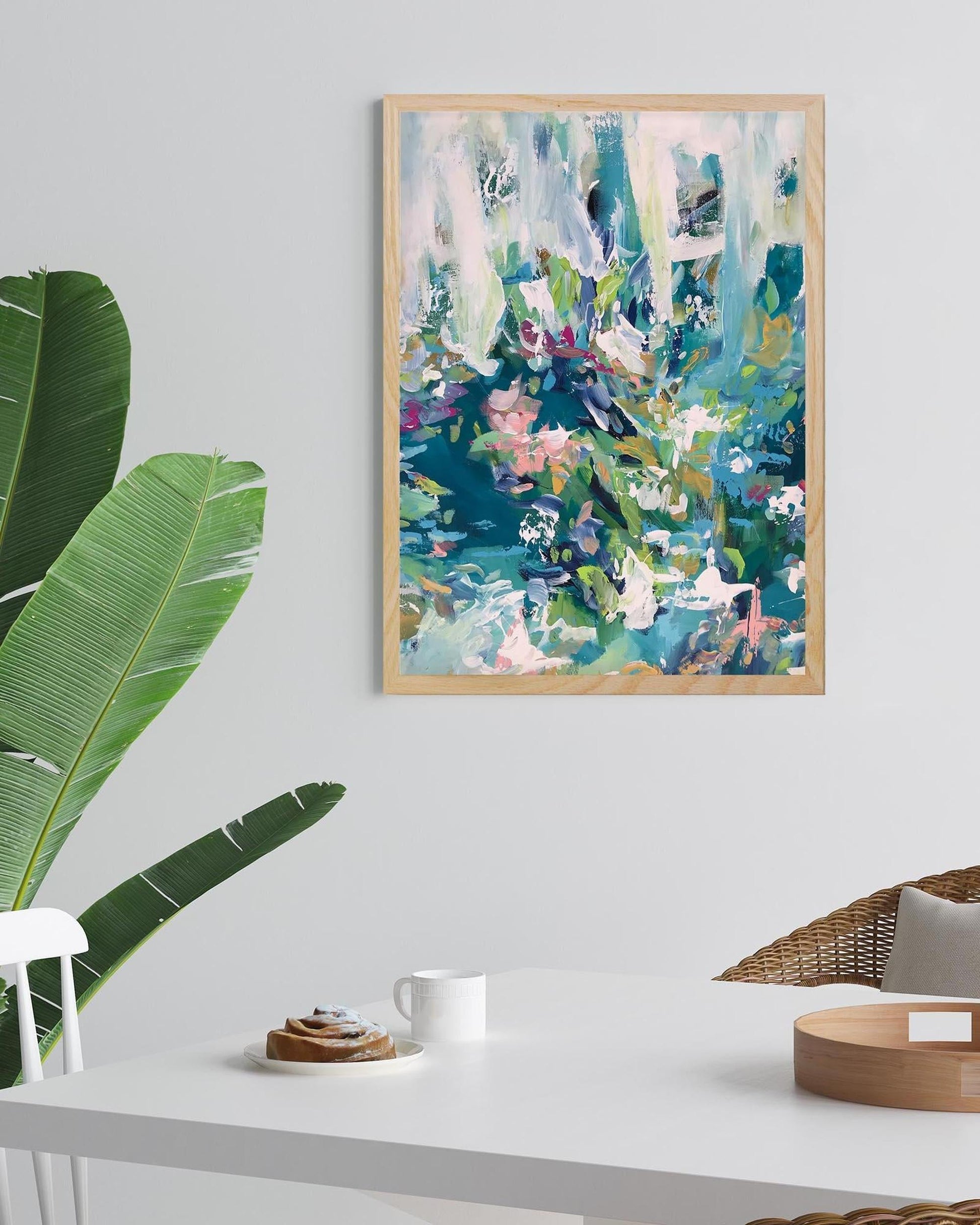 Abstract painting on a wall with a table and plant in the foreground