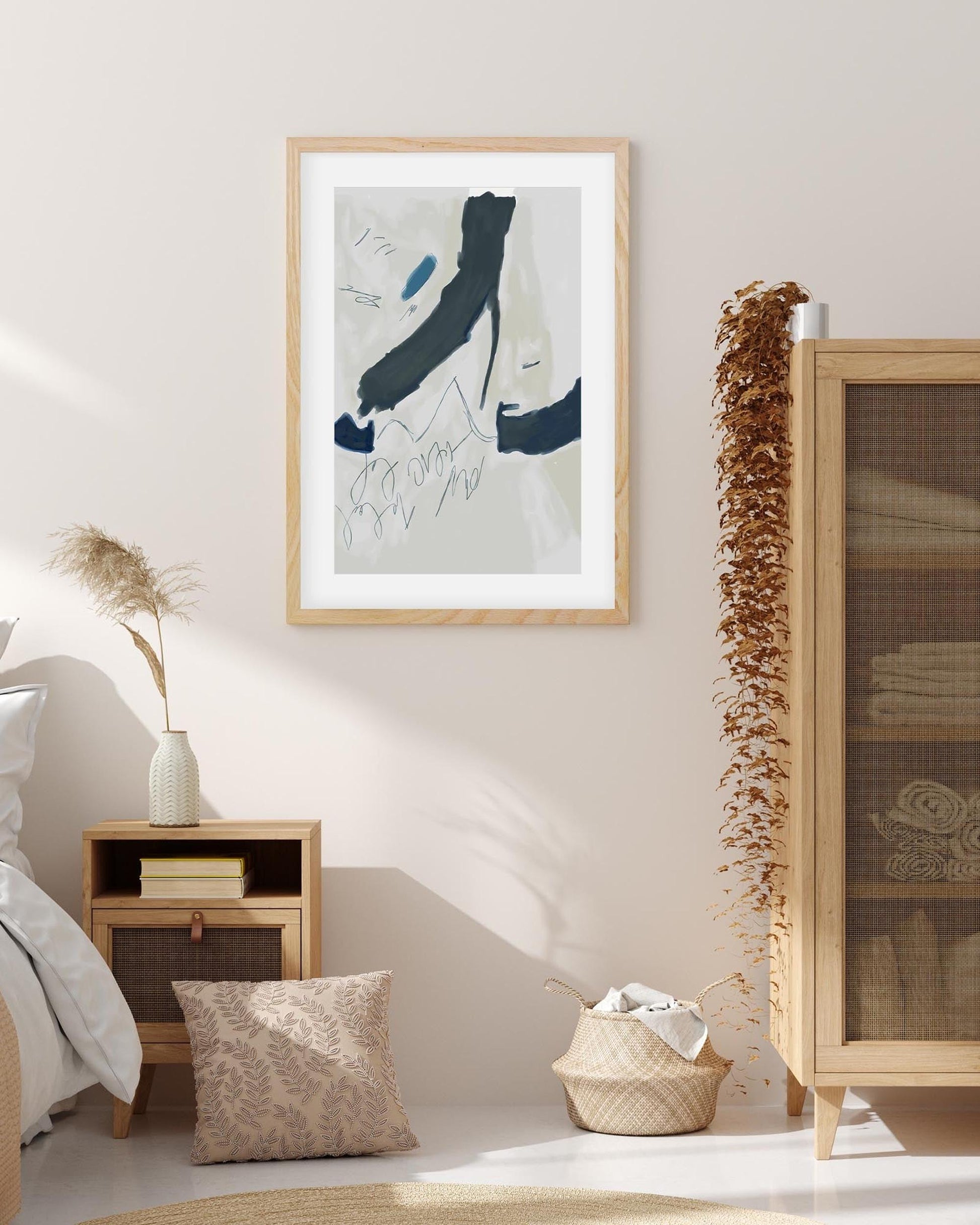 Framed abstract art piece on a wall in a room with decor elements.