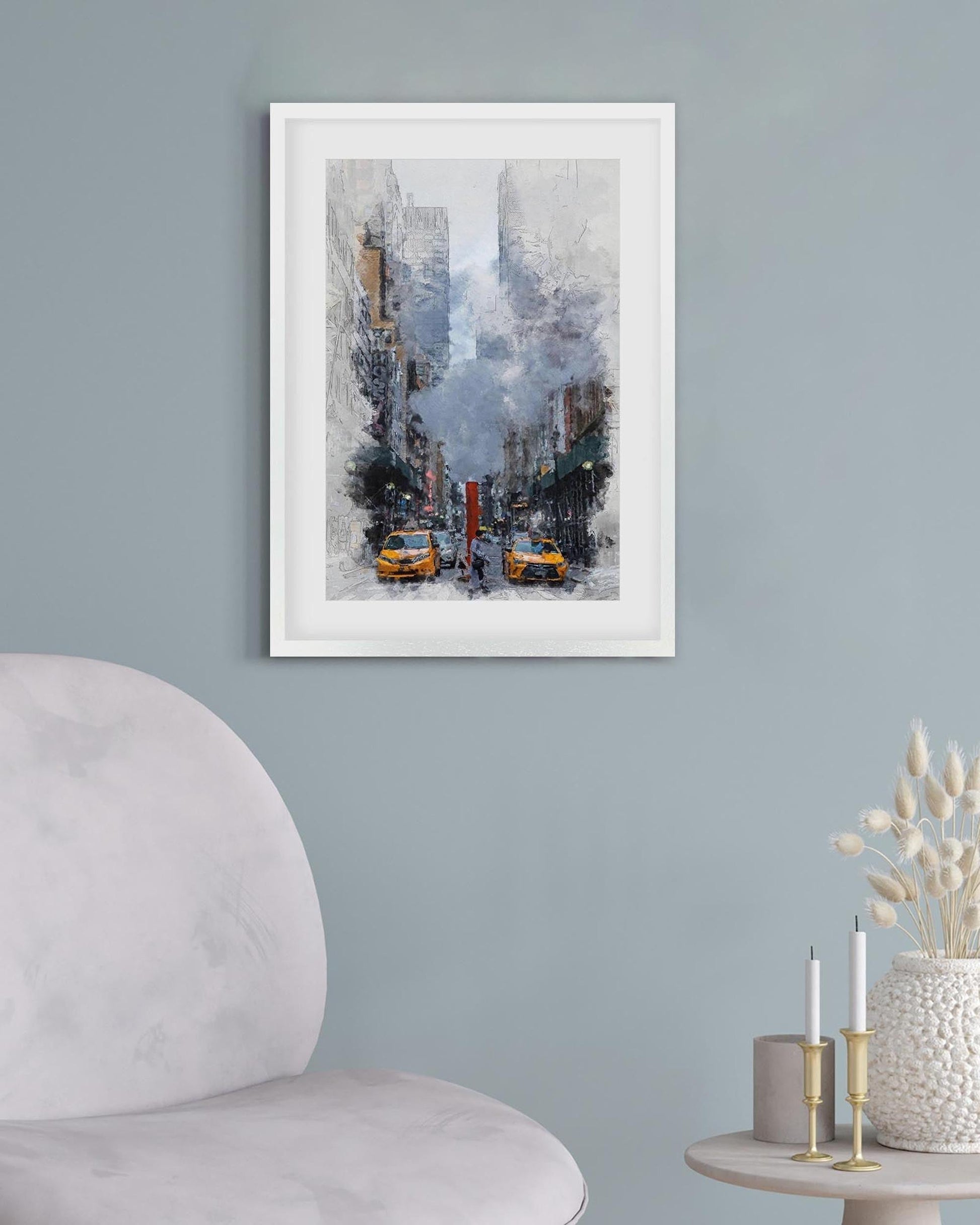 Framed artwork of a city street scene with taxis on a light blue wall.