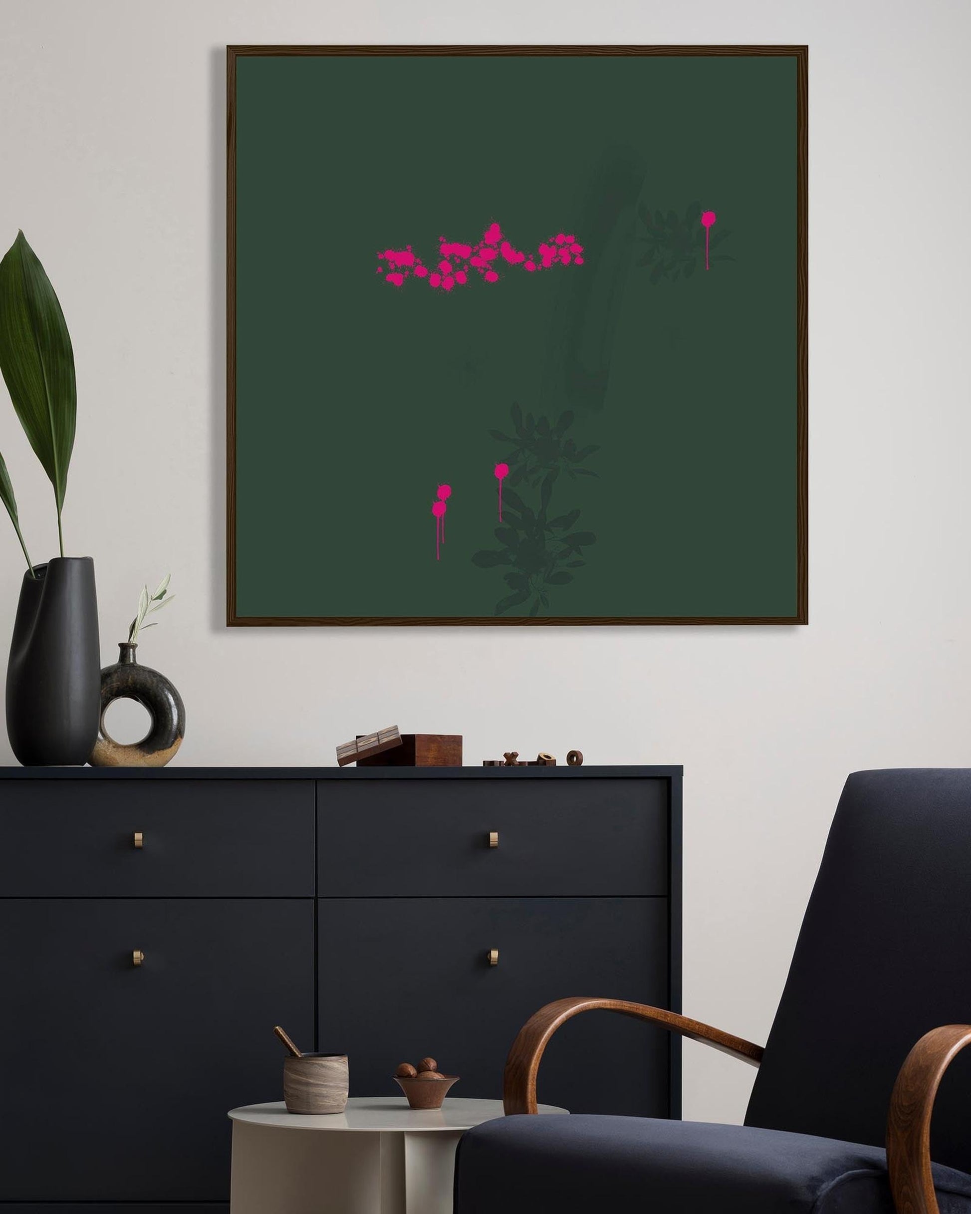 Framed abstract artwork with pink elements on a green background in a modern living room.