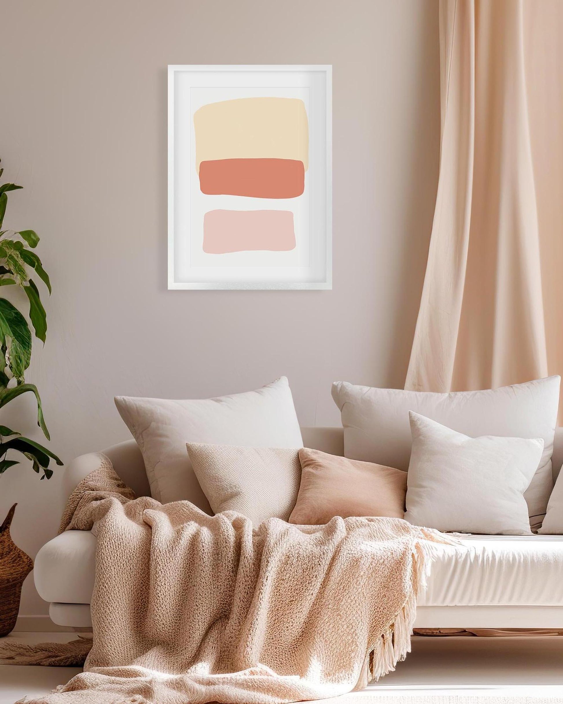 Living room with a beige sofa, white pillows, a blanket, and a abstract art print on the wall.