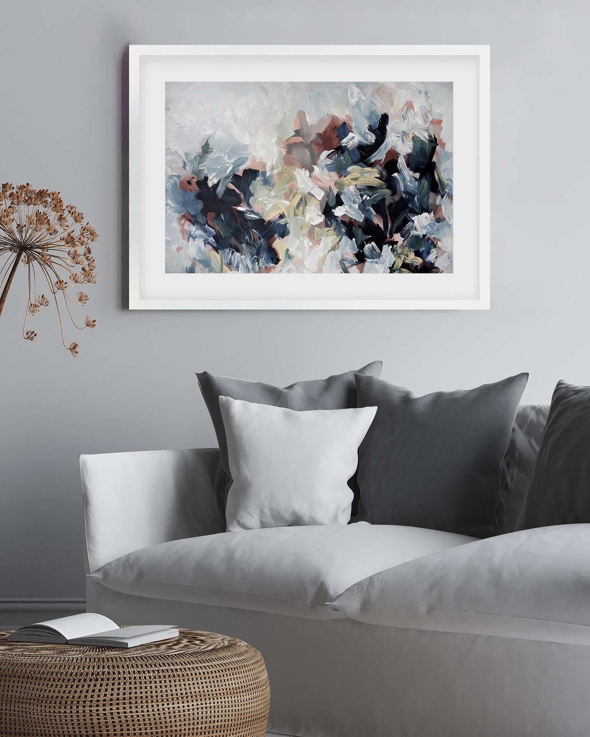 Abstract painting on a gray wall above a sofa with decorative pillows.