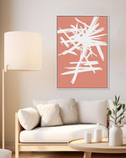 A white and orange abstract sketch canvas art hanging on a wall over a white sofa in a living room setting with a lamp, plant, and candles.