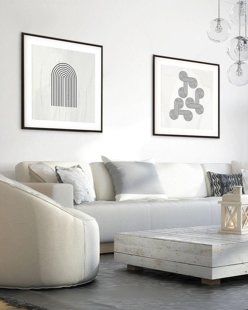 Modern living room with a white sofa, coffee table, and framed artwork on the wall.
