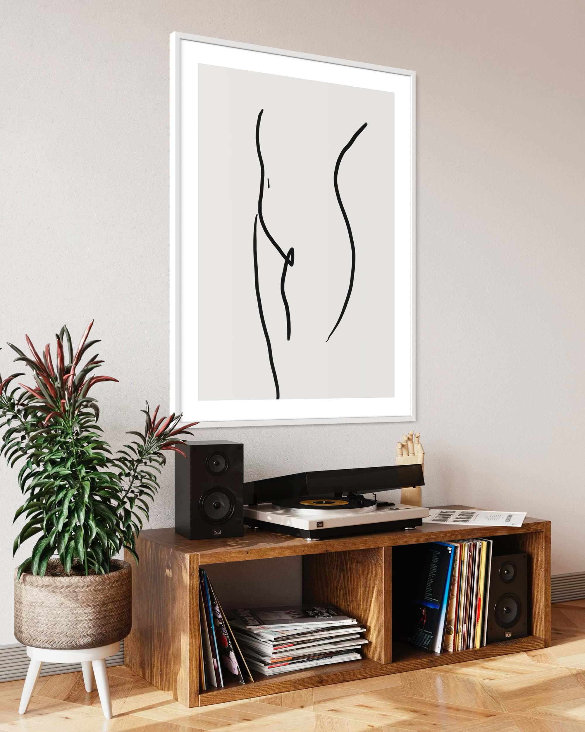 Framed abstract art above a wooden entertainment console with records and speakers.