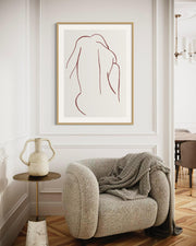 Modern interior with a framed abstract art piece on the wall above a cozy armchair.