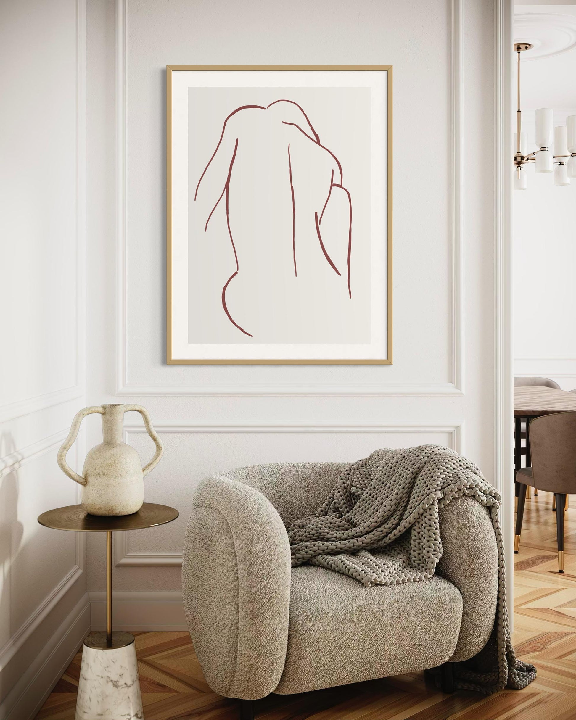 Modern interior with a framed abstract art piece on the wall above a cozy armchair.