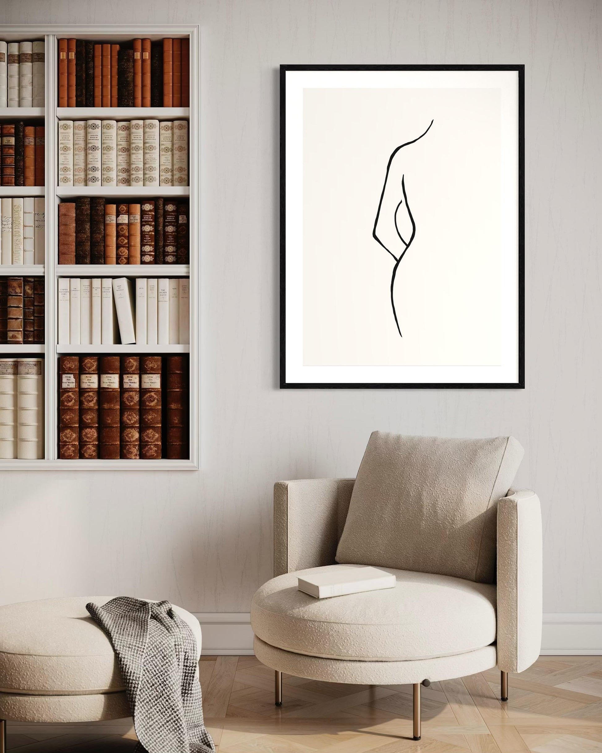 Modern interior with a bookshelf, armchair, and abstract art on the wall.