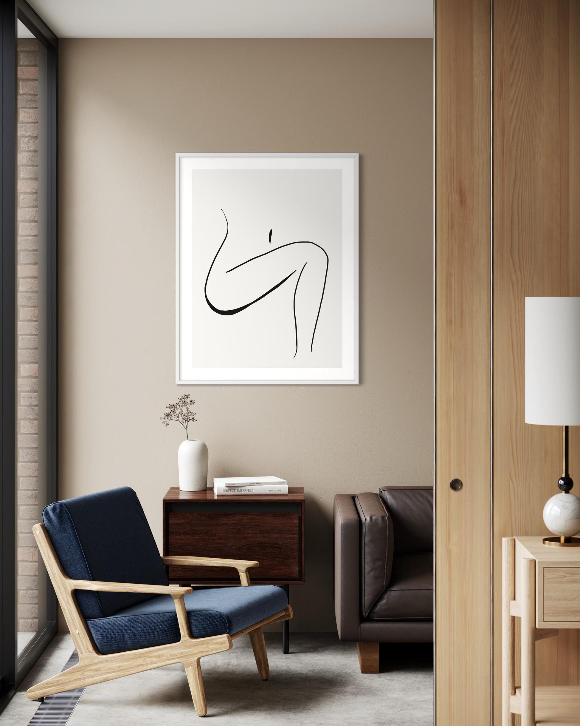 Modern interior with a blue armchair, wooden side table, and abstract art on the wall.