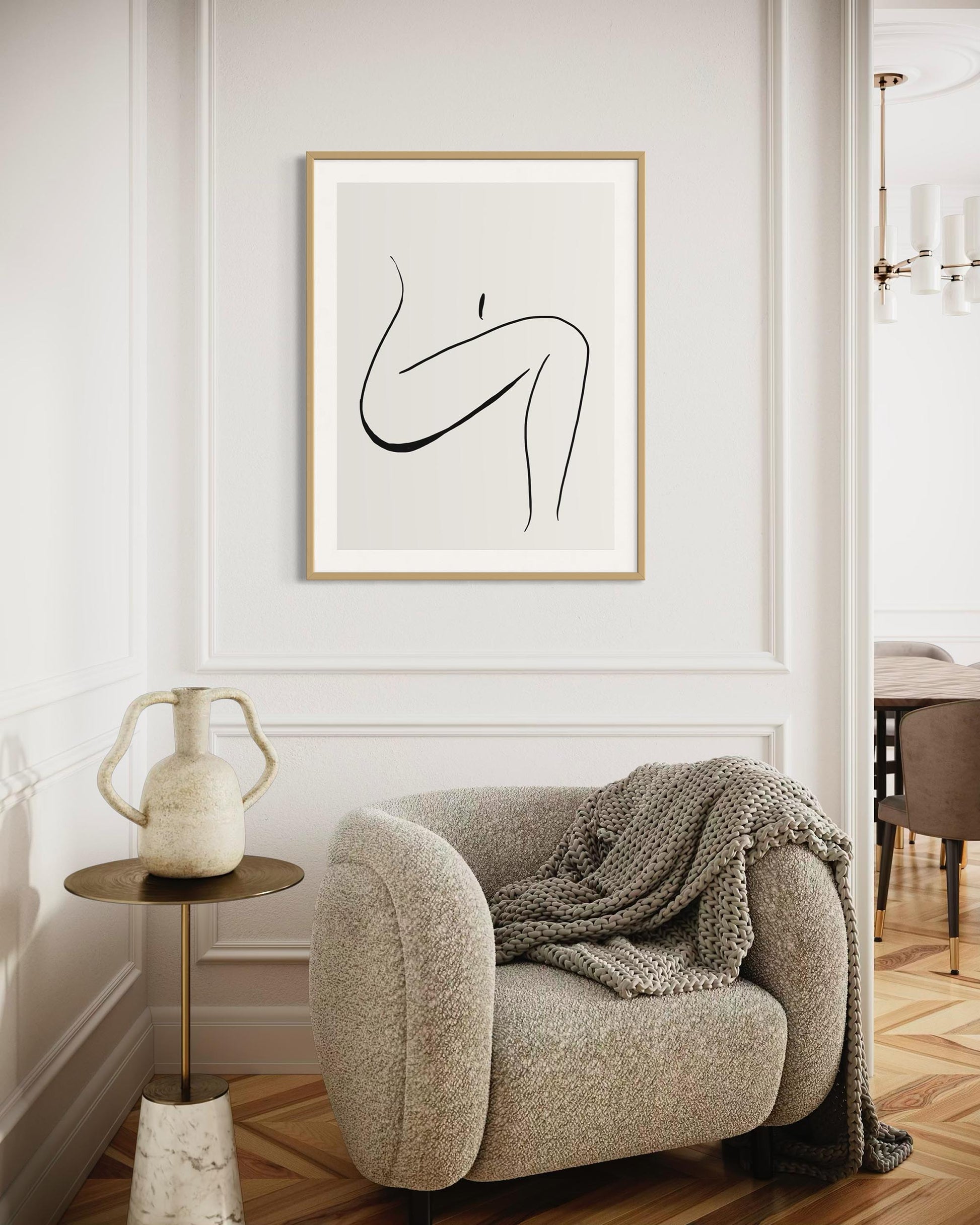 Modern interior with a beige armchair, side table, and abstract art on the wall.