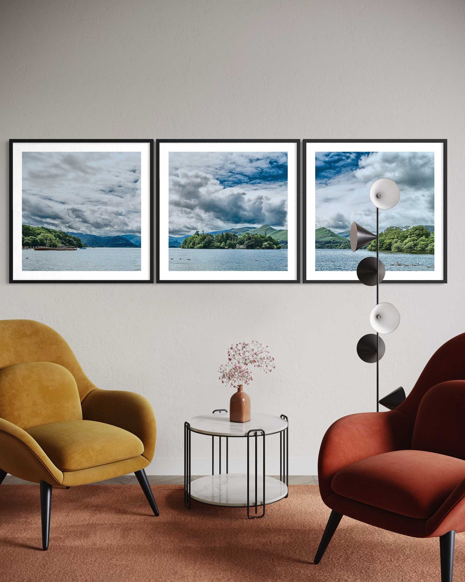 Living room with two armchairs, a side table, and wall art depicting landscapes.