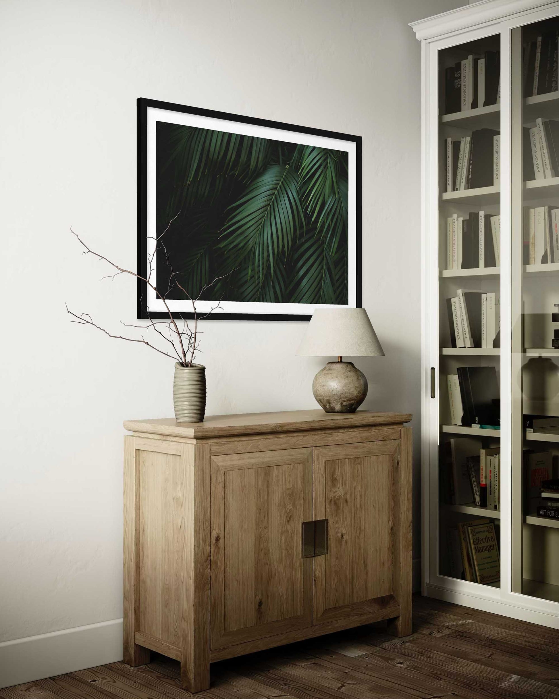Wooden cabinet with decorative items in a room with a bookshelf.