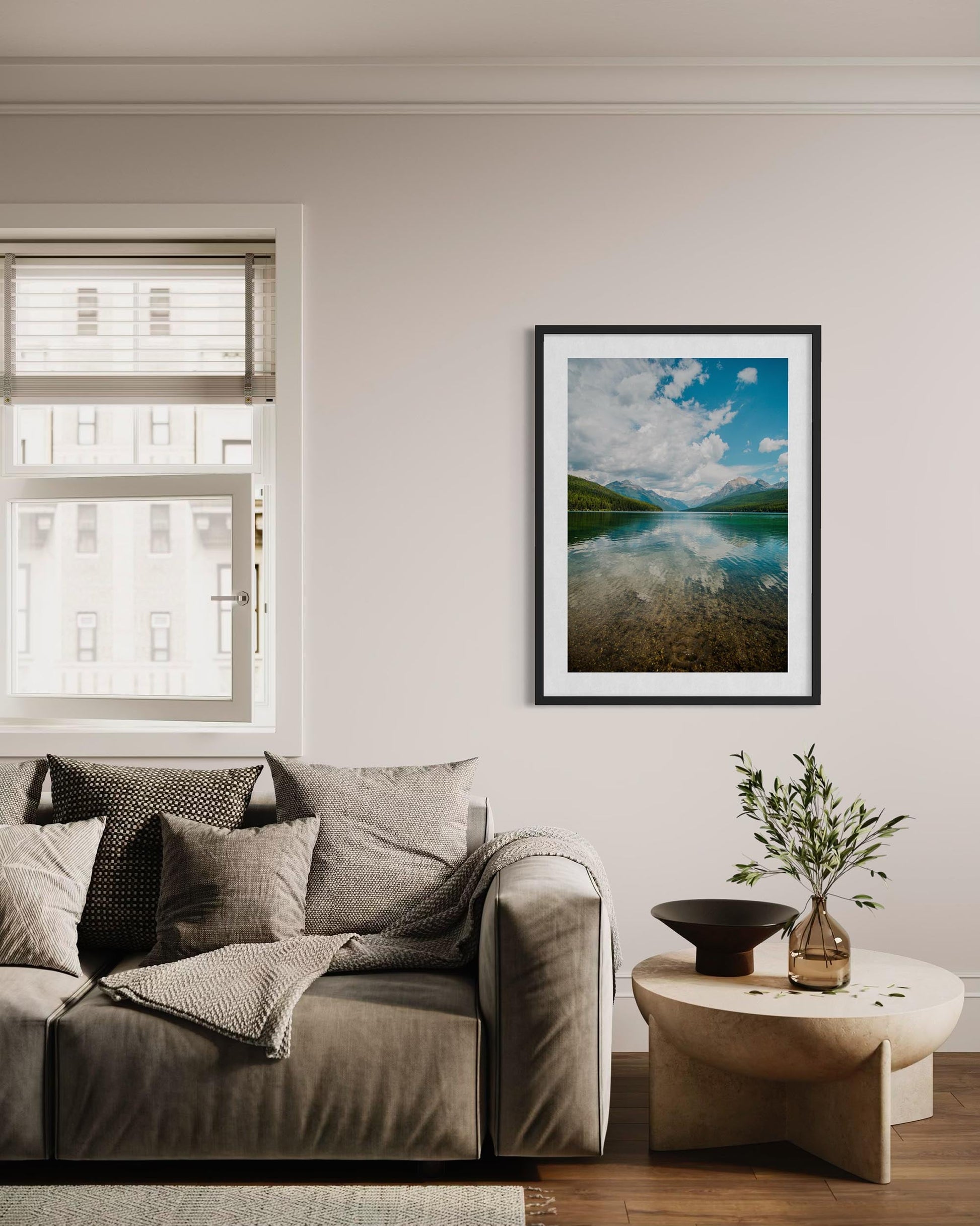 Living room with a sofa, coffee table, and framed landscape picture on the wall.