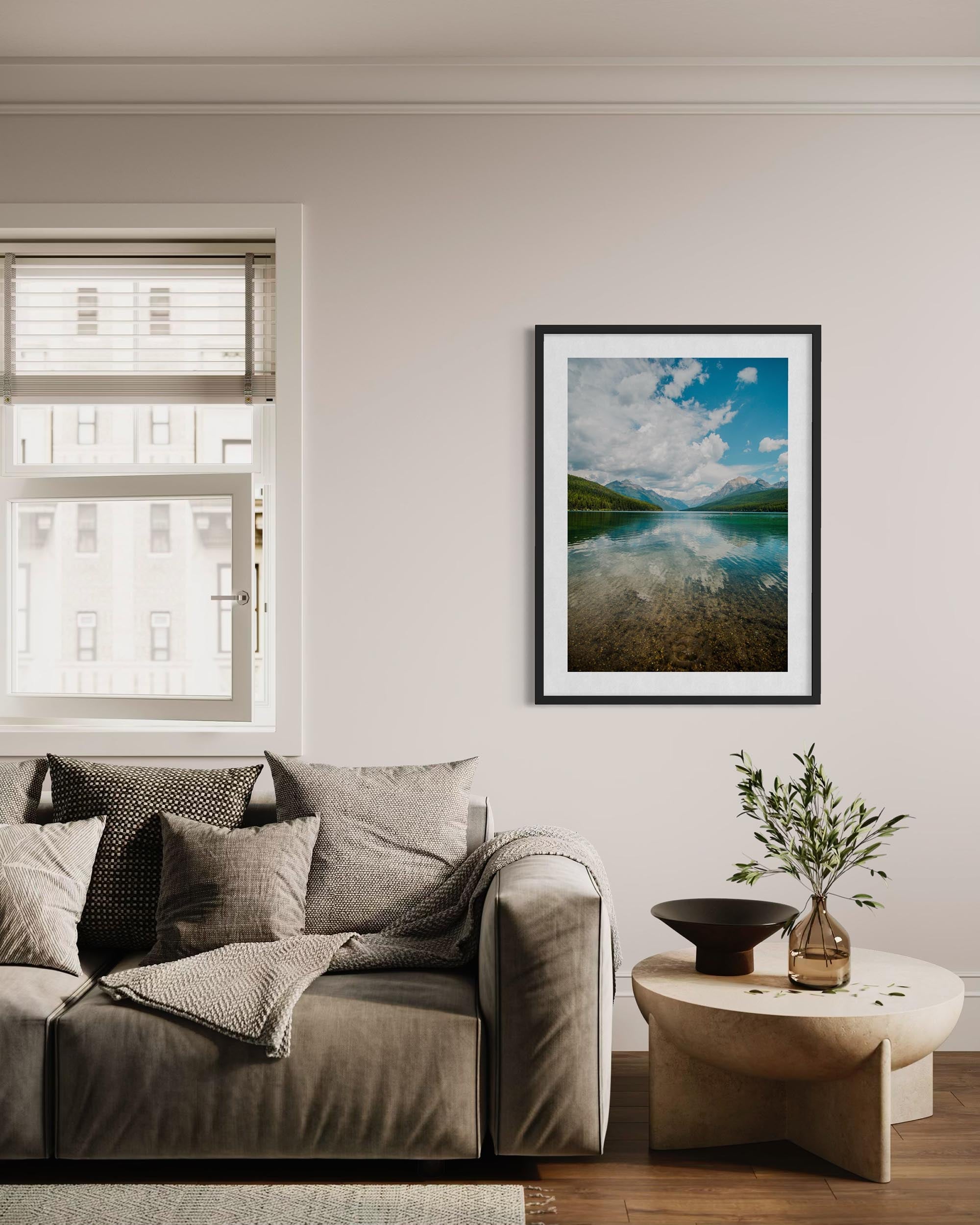 Living room with a sofa, coffee table, and framed landscape picture on the wall.