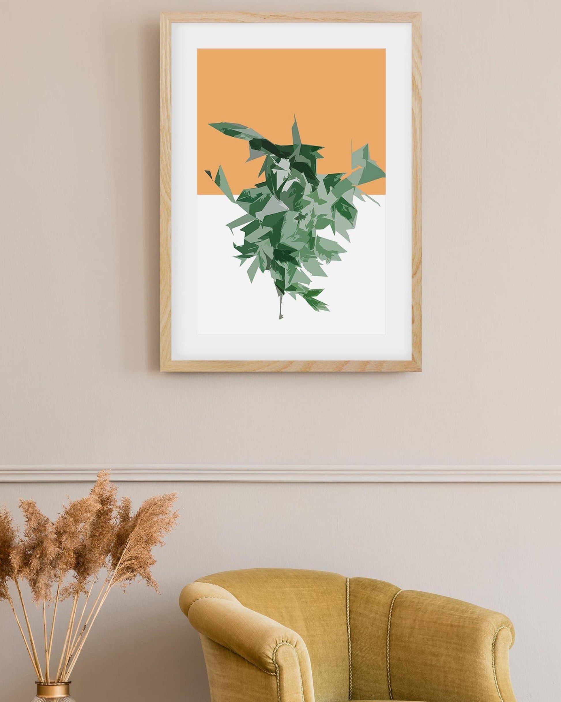 Framed artwork of green leaves on an orange background above a yellow armchair.