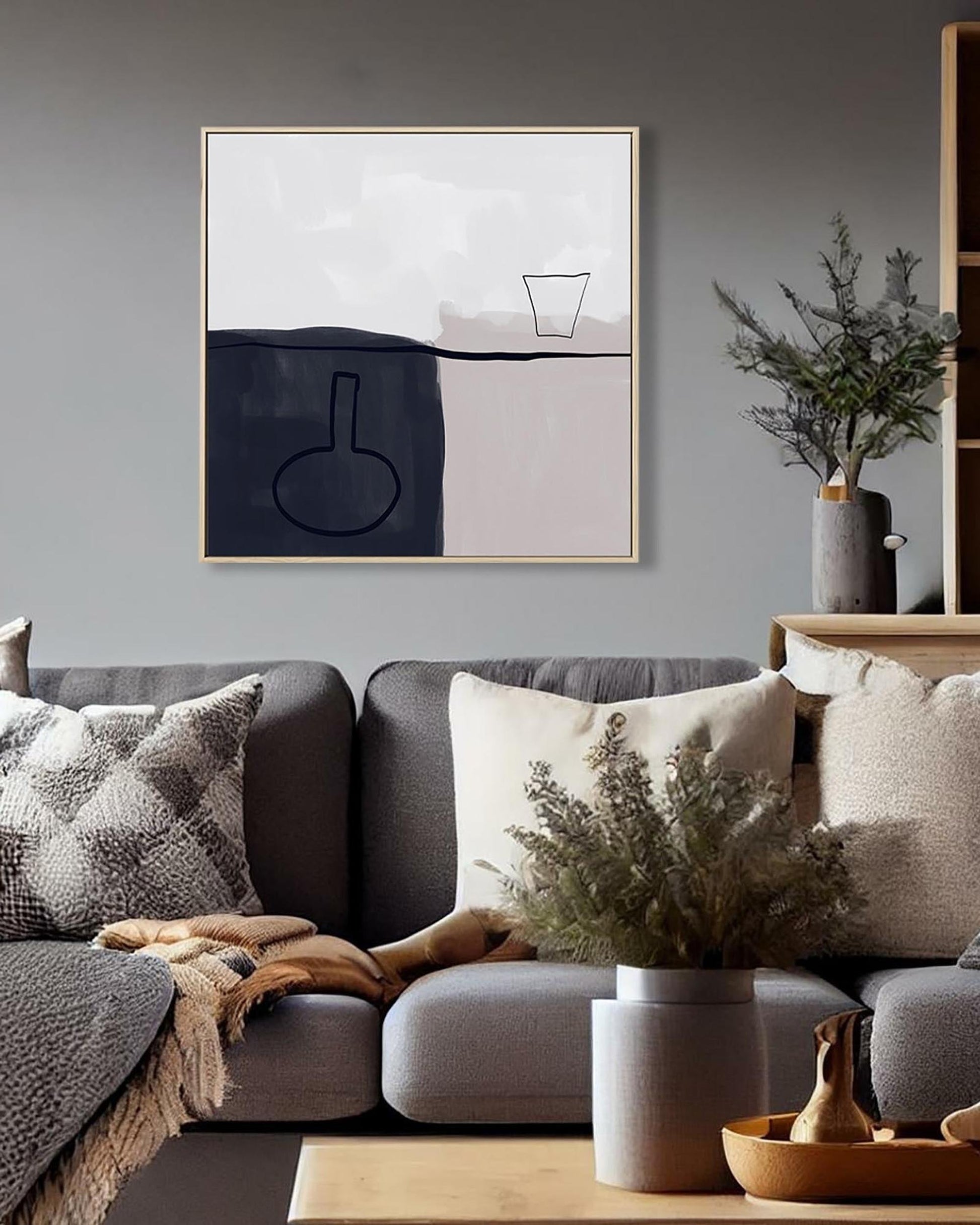 Modern living room with a gray sofa, abstract art, and decorative elements.