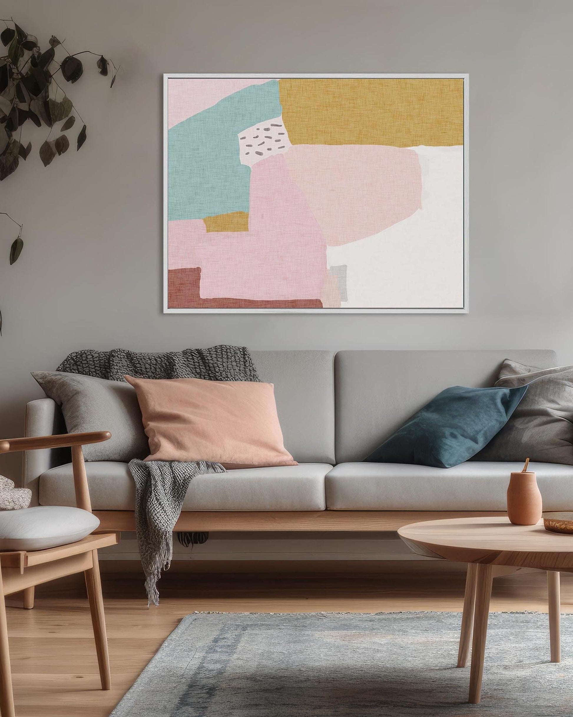 Living room with a gray sofa, wooden chair, and abstract art on the wall.