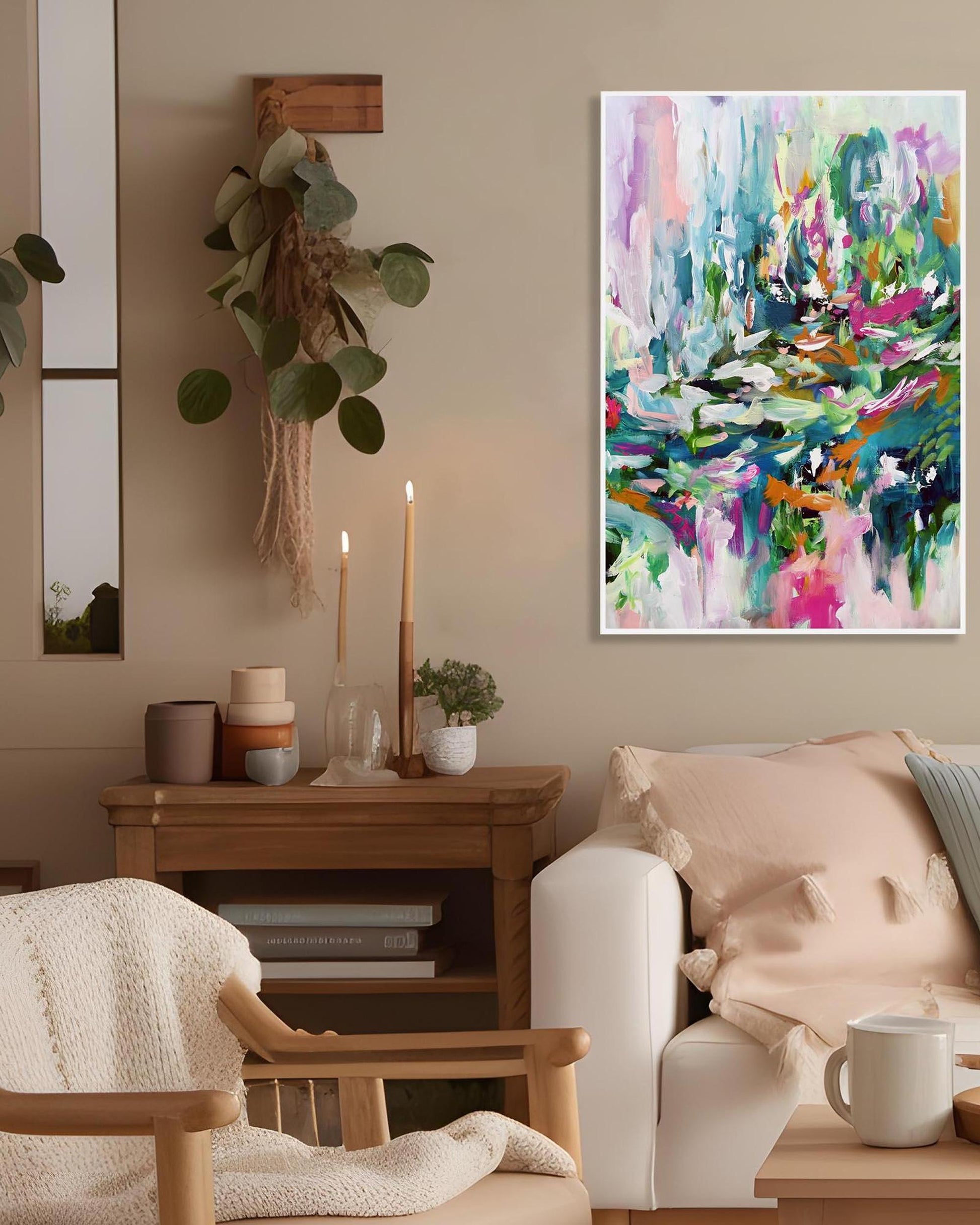 Living room with a colorful abstract painting on the wall, a wooden side table with candles and decor, and a white sofa.