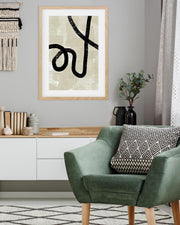 Modern living room with a green armchair, decorative pillow, and framed abstract art on the wall.