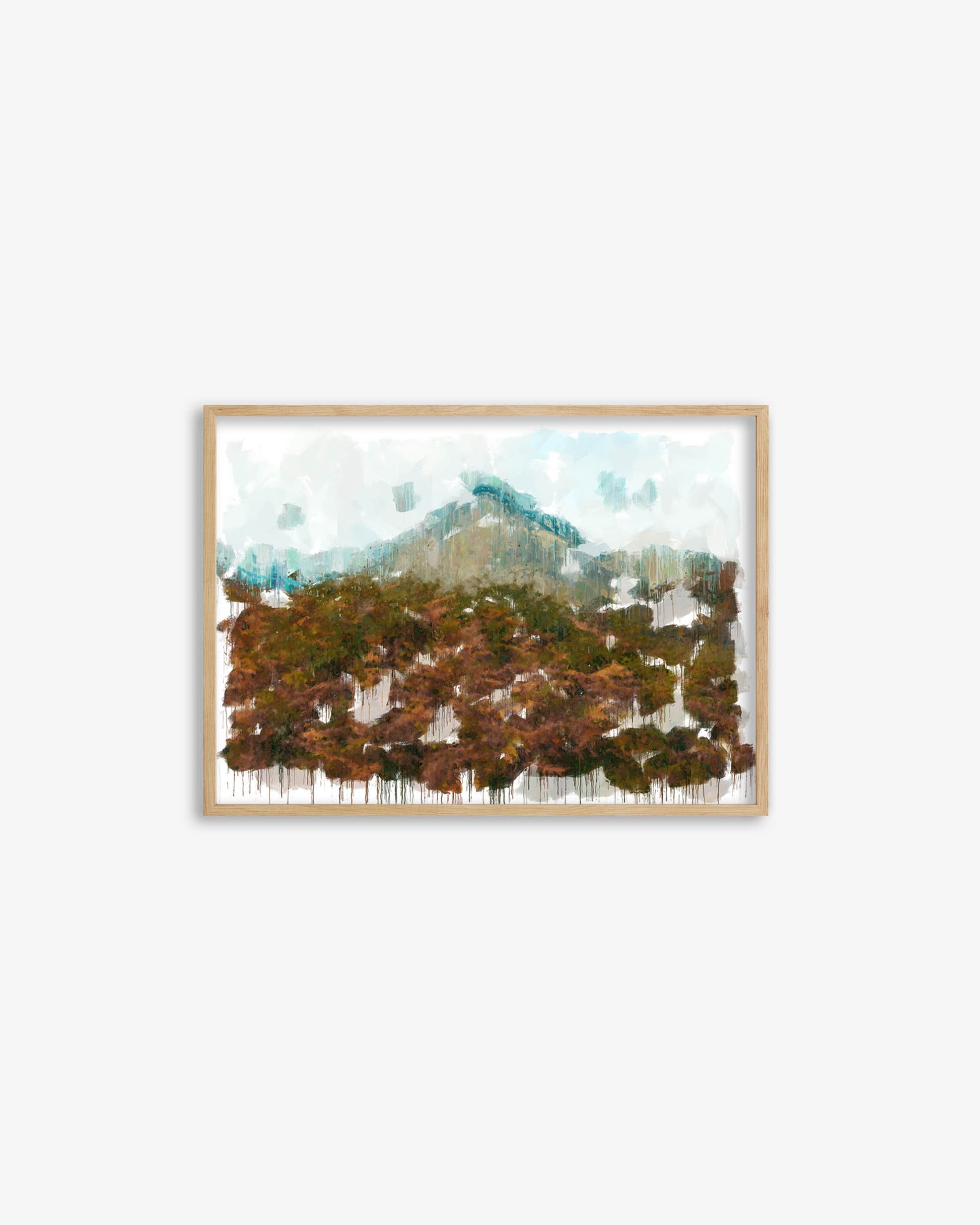 Framed artwork of a mountain landscape with trees on a white wall