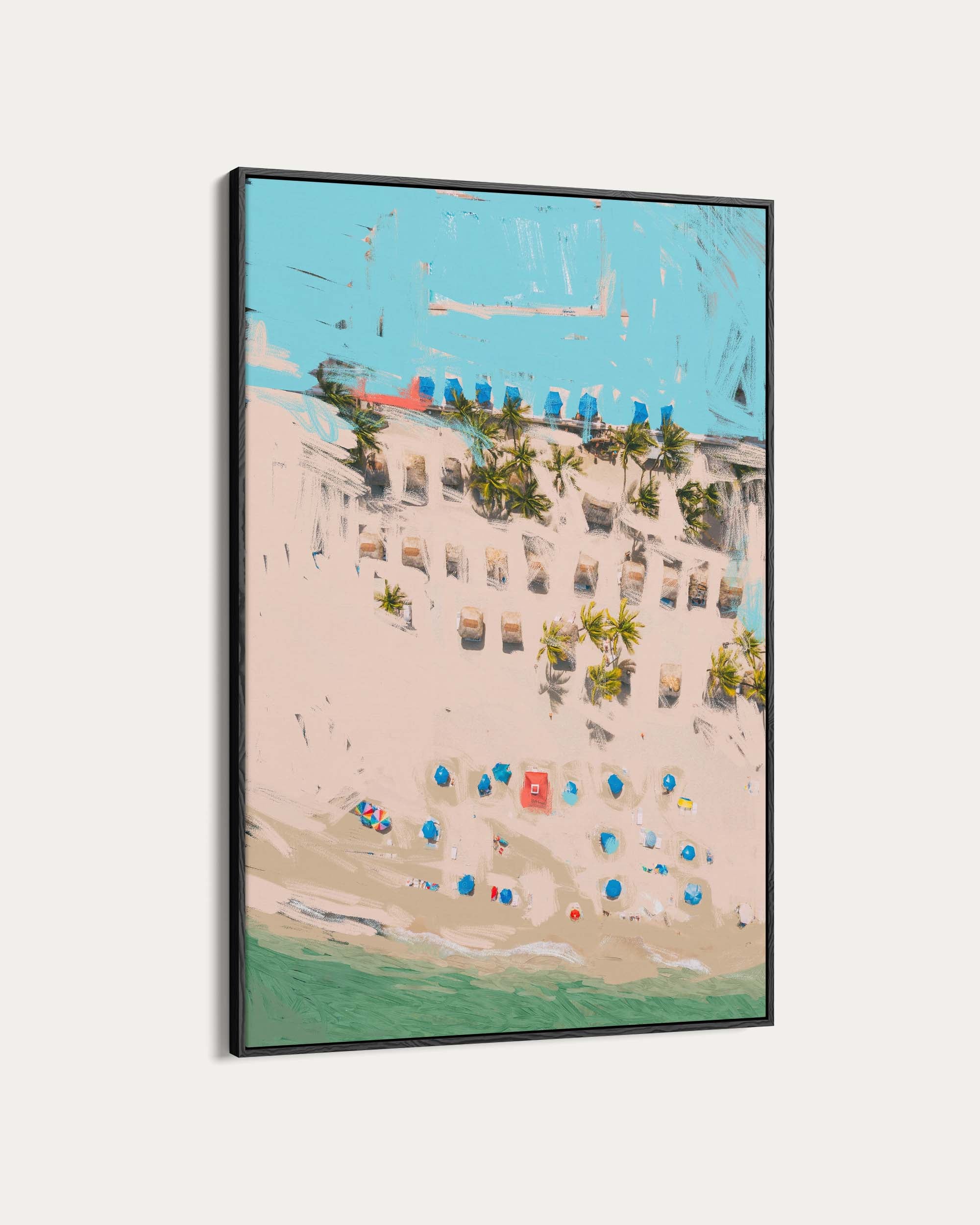 Framed artwork of a beach scene with buildings and umbrellas.