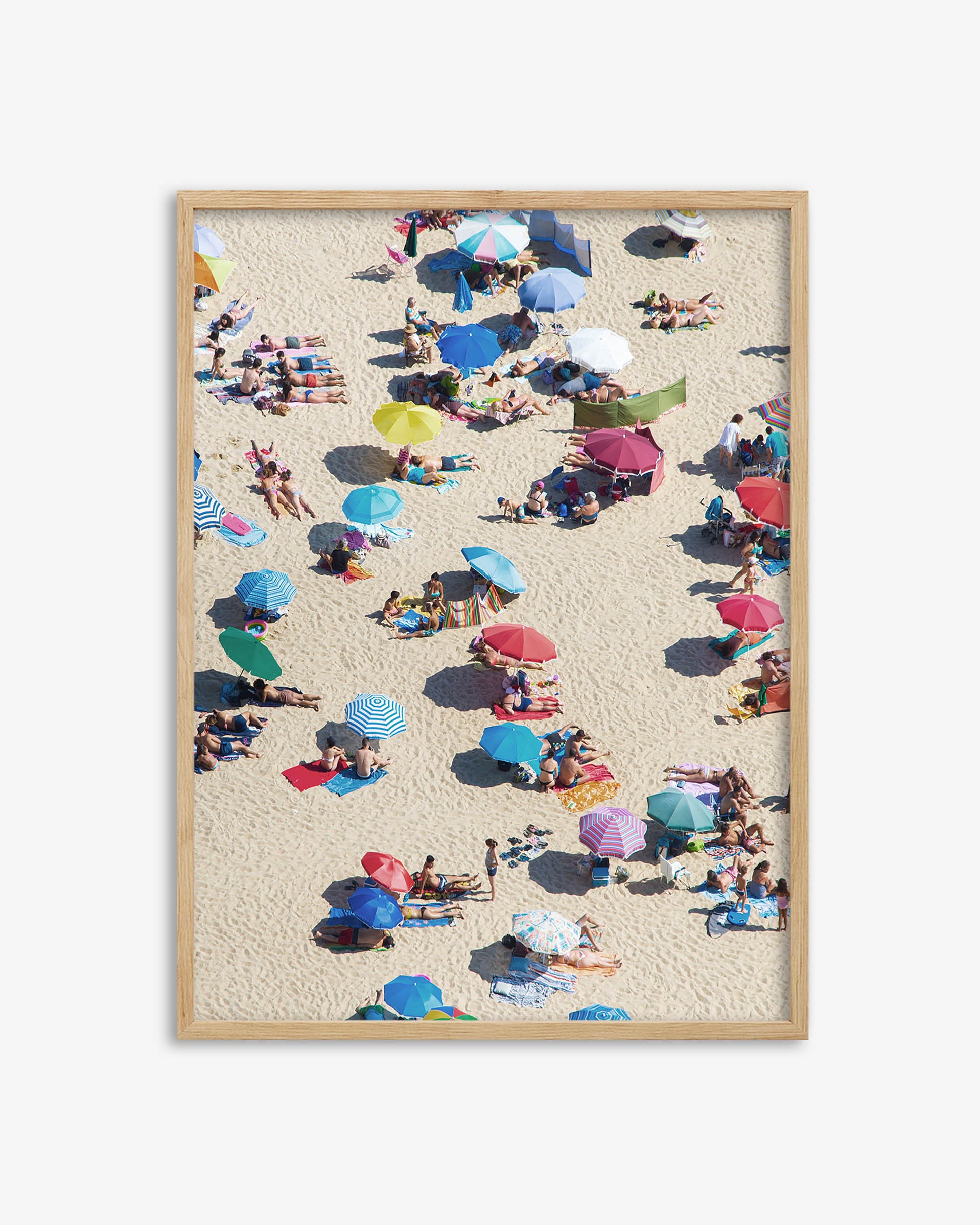 Framed artwork of a beach scene with people and colorful umbrellas.