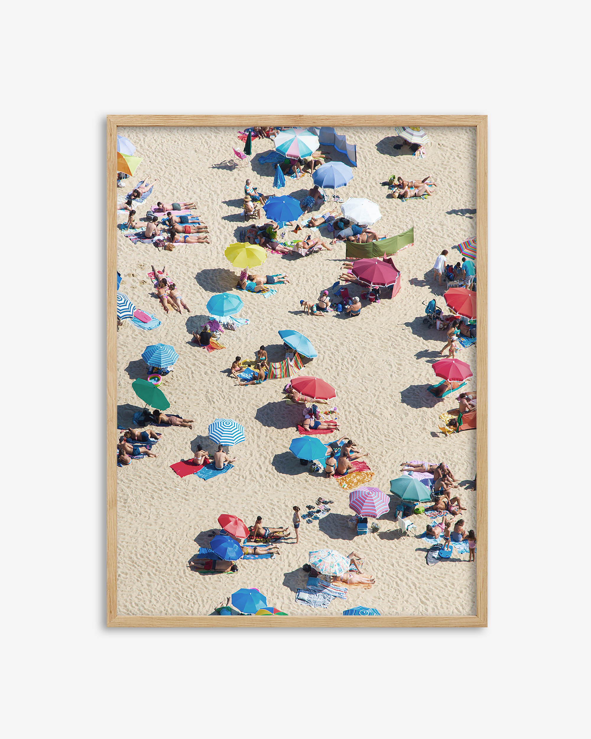 Framed artwork of a beach scene with people and colorful umbrellas.