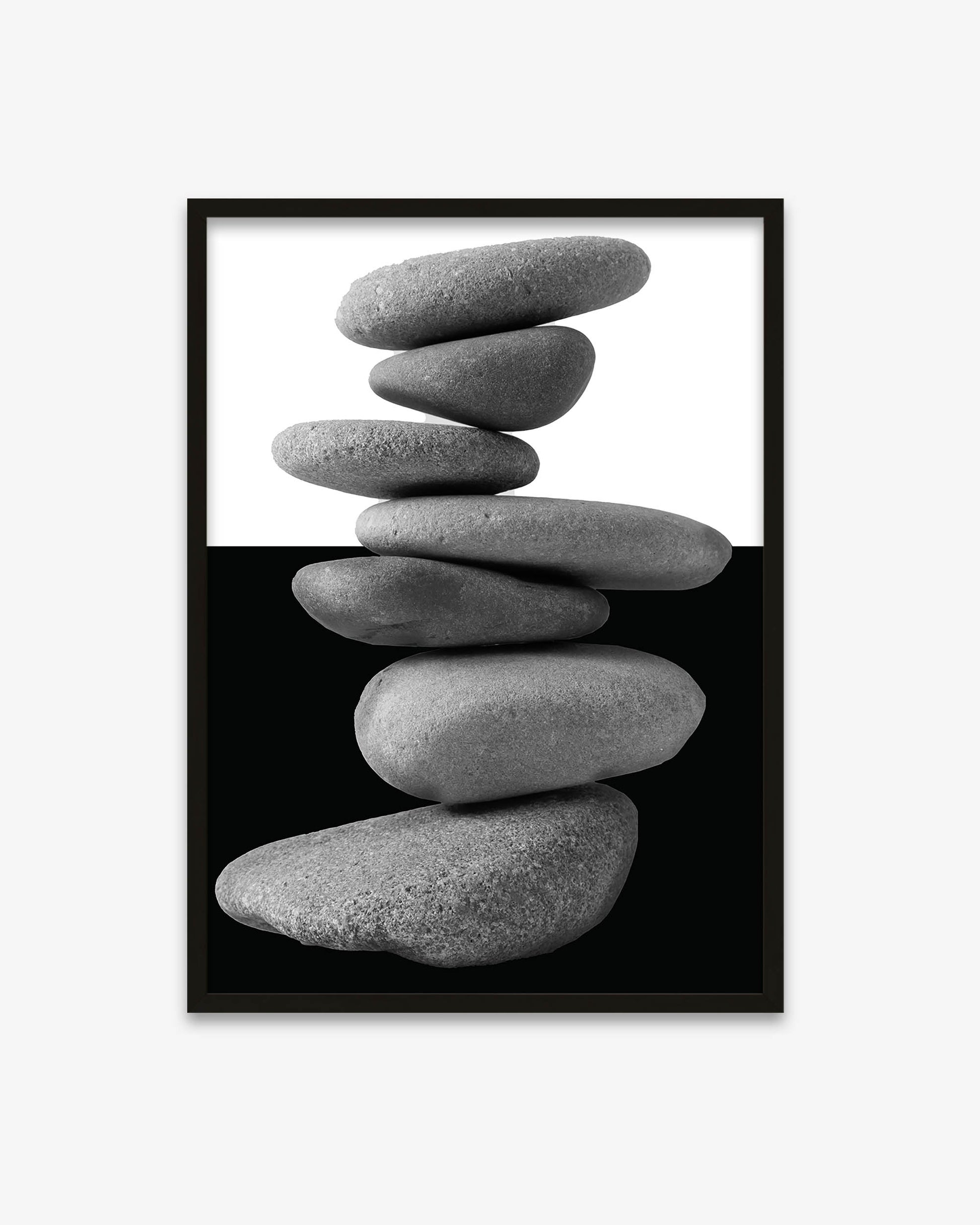 Framed artwork of stacked stones on a white background