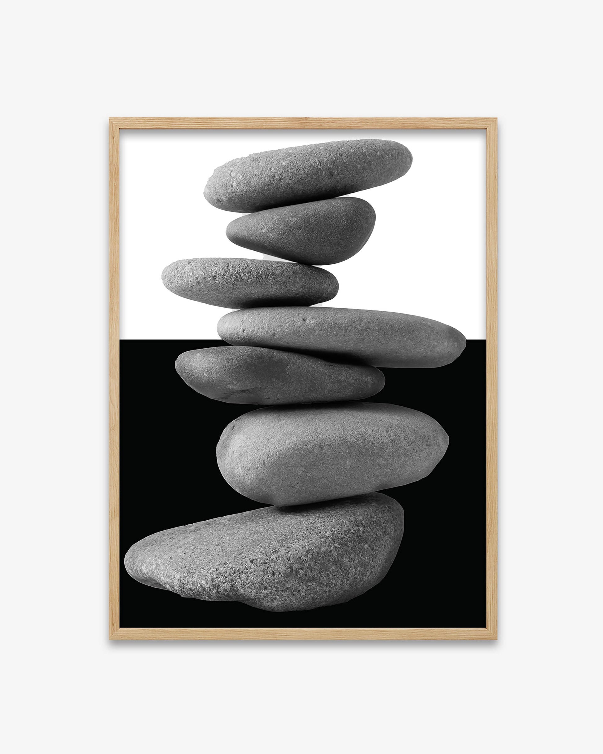 Framed artwork of stacked stones on a black background