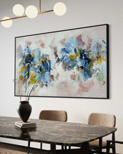 Abstract floral painting on a wall above a dining table with chairs.