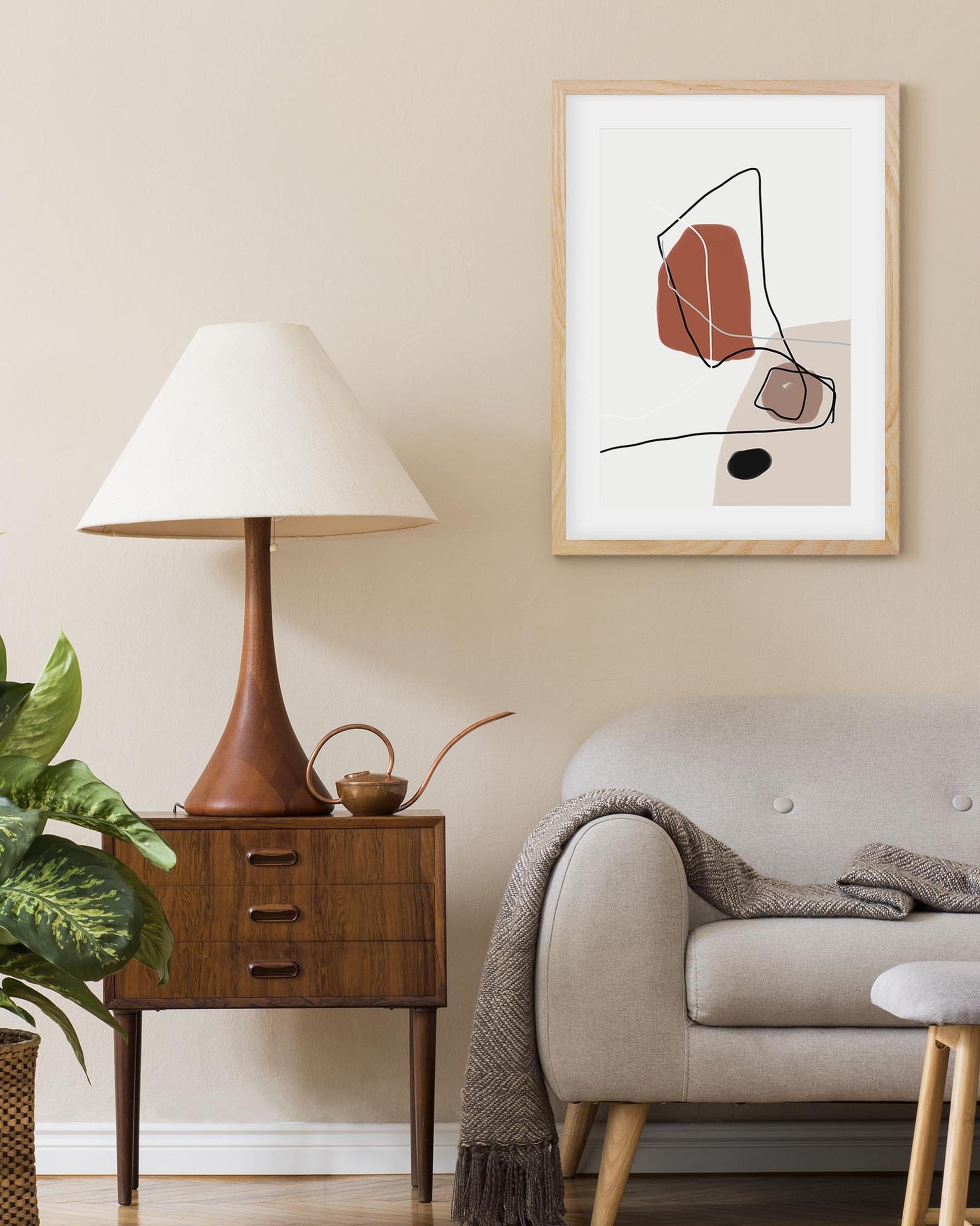 Modern living room with a lamp, side table, sofa, and abstract art on the wall.