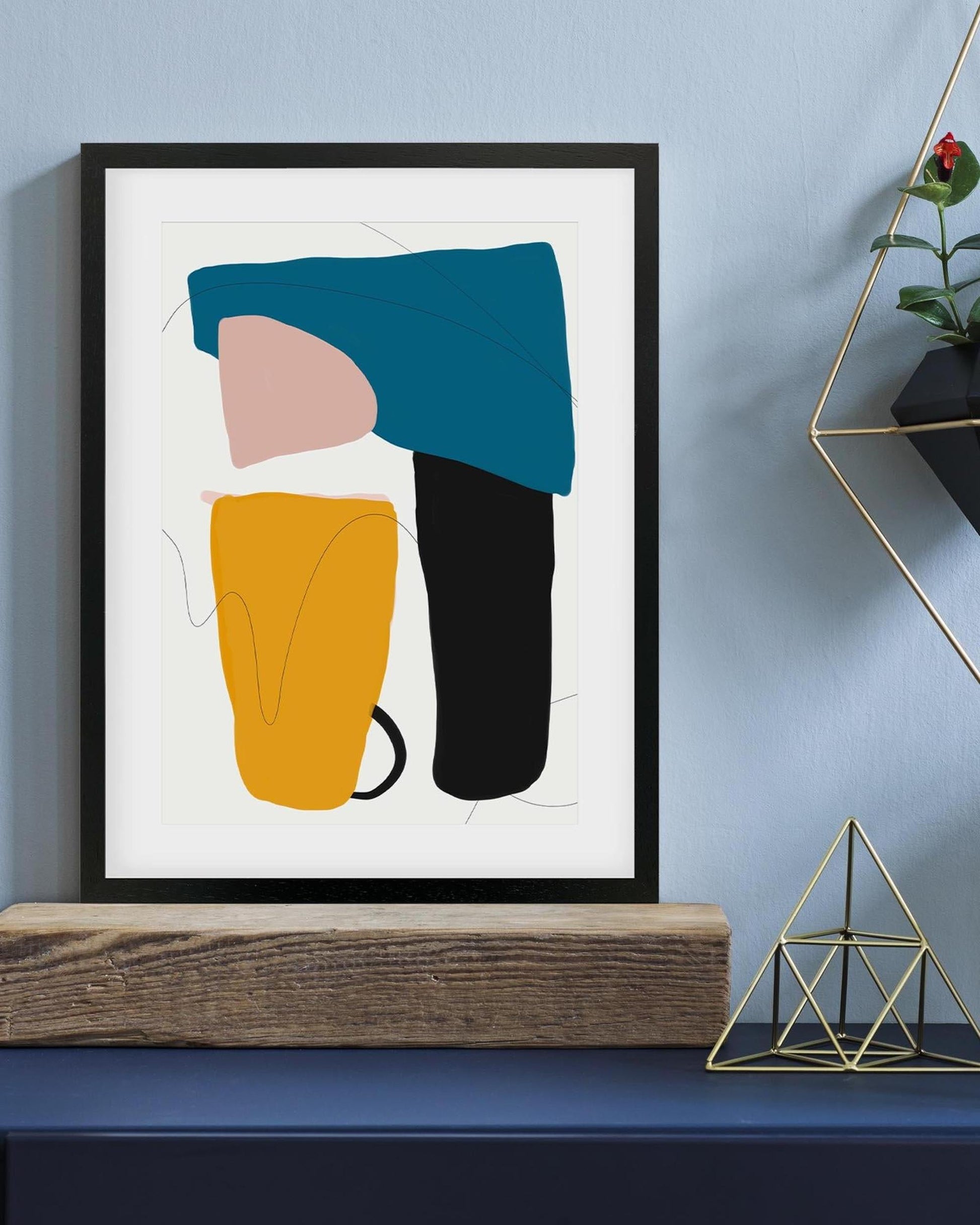 Framed abstract art piece with geometric shapes on a wall.