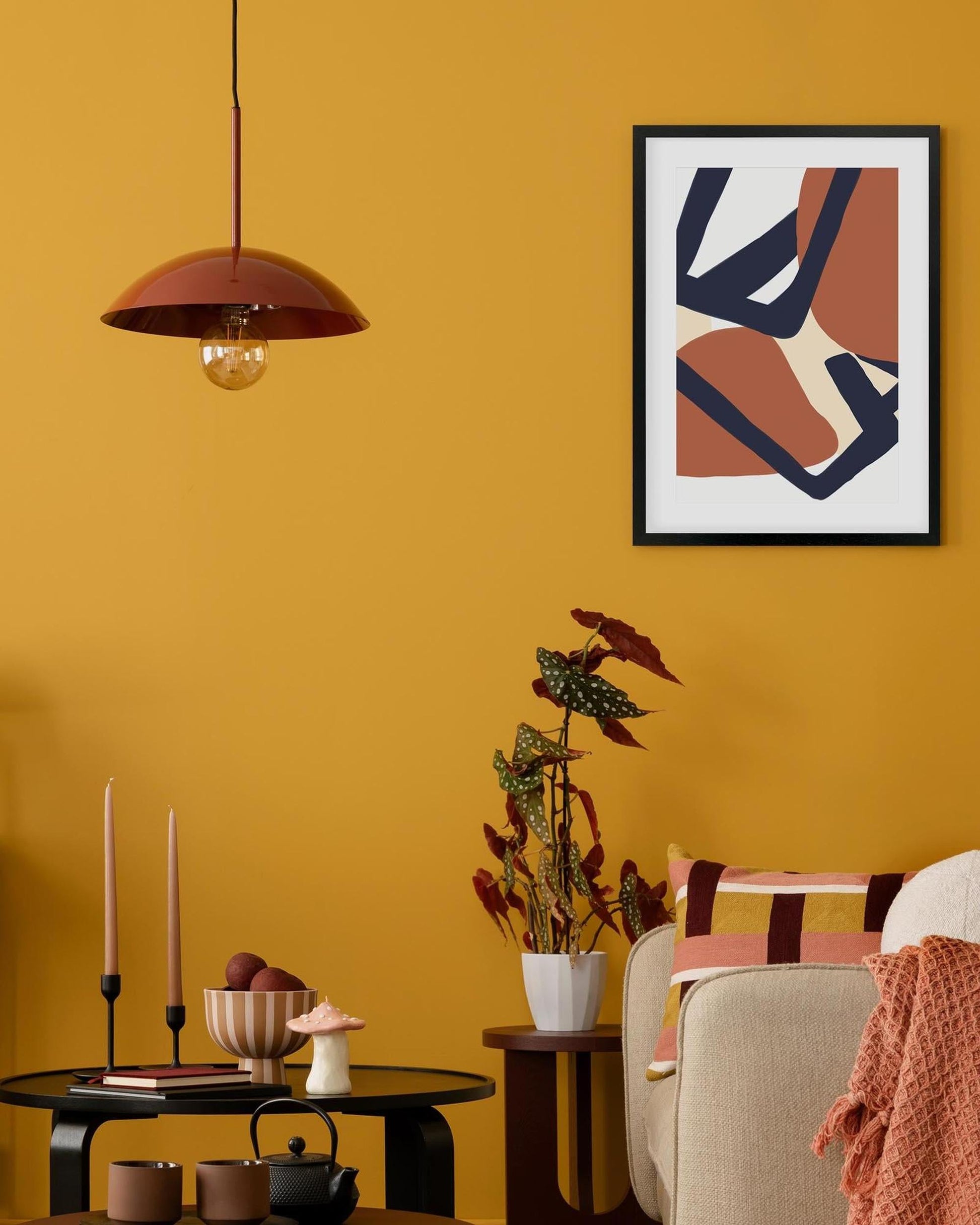 Living room with yellow walls, a modern abstract art piece, and decorative items.
