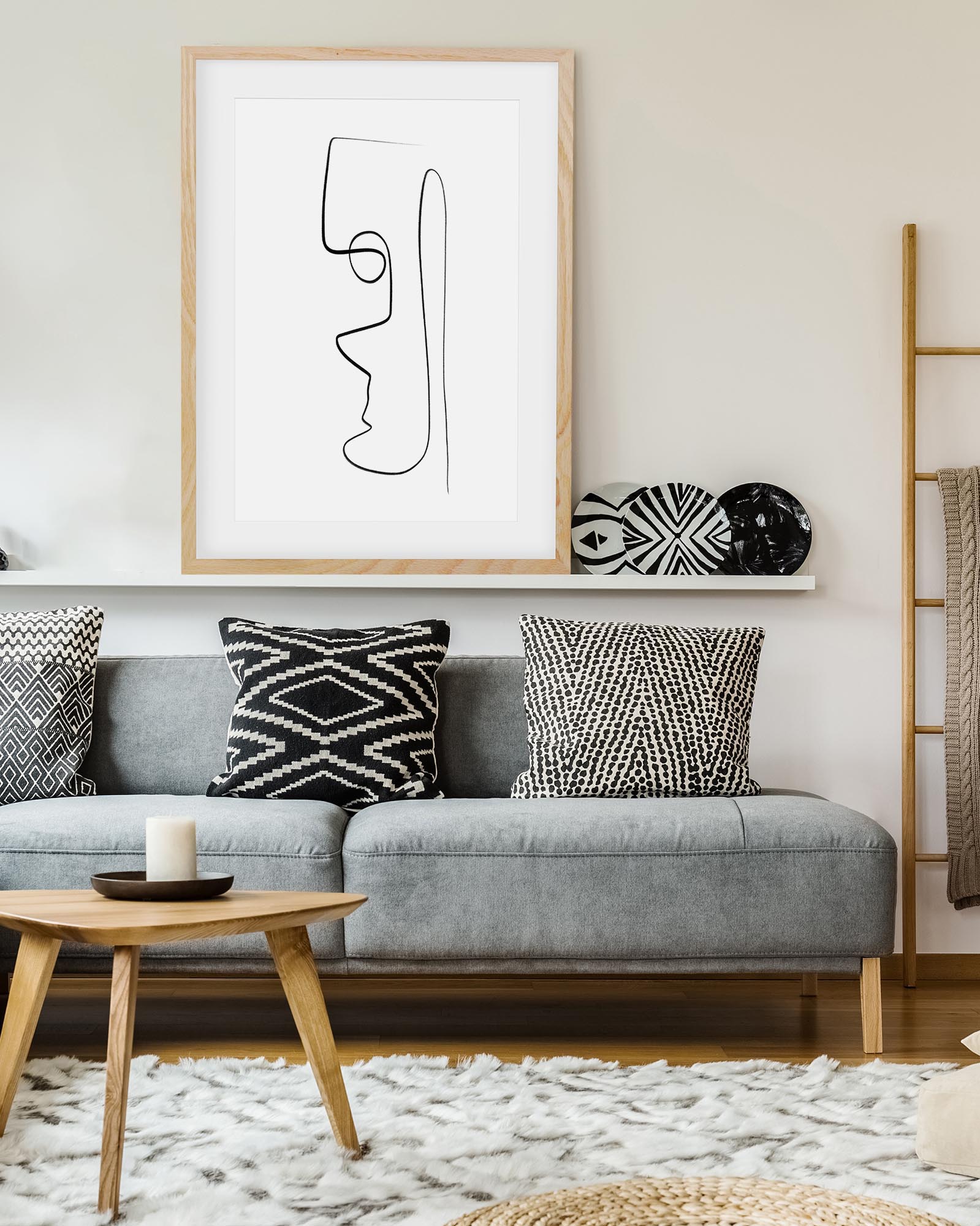 Living room with a gray sofa, decorative pillows, and a framed abstract art piece on the wall.