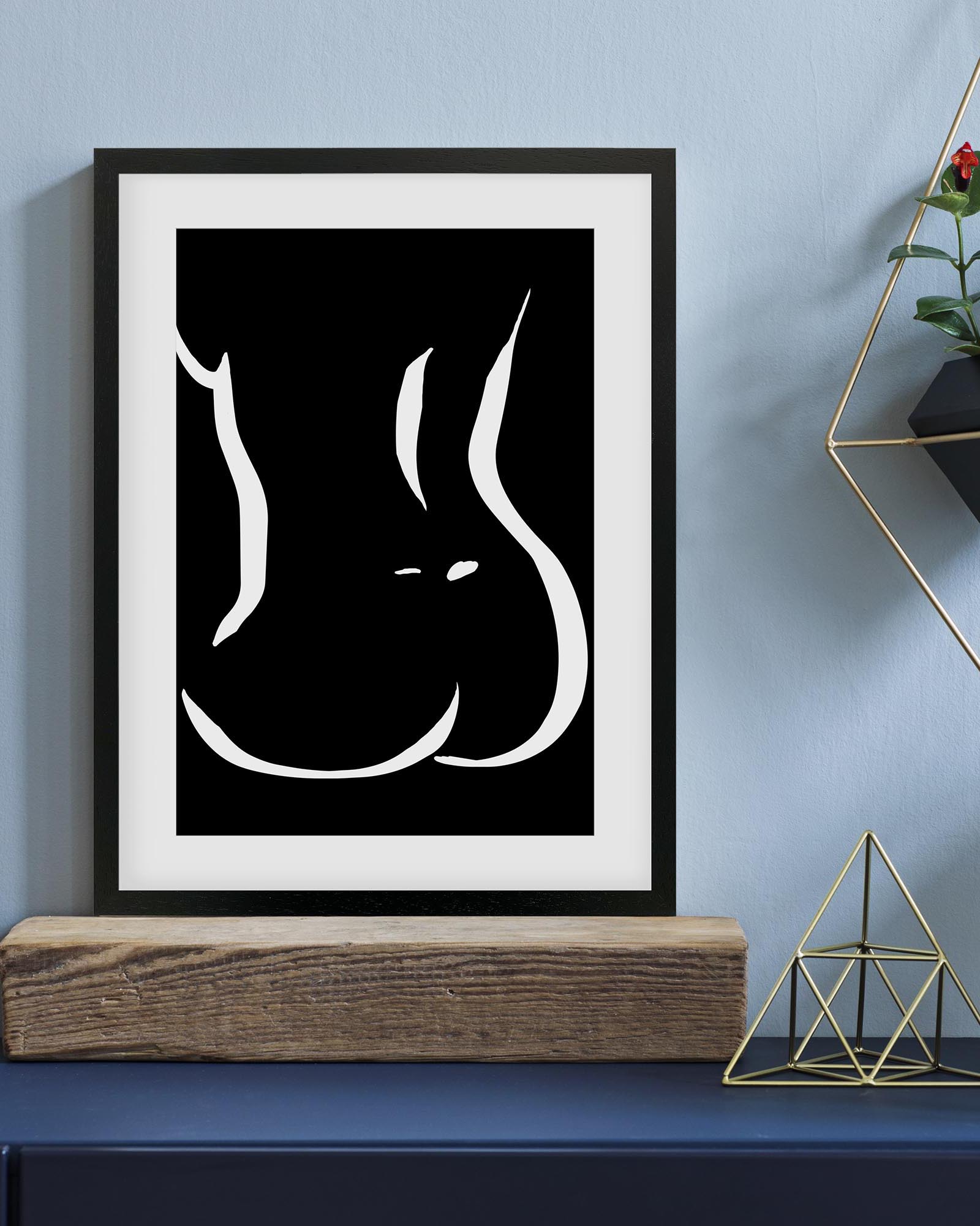 Framed artwork of a stylized face on a blue wall with decorative elements.