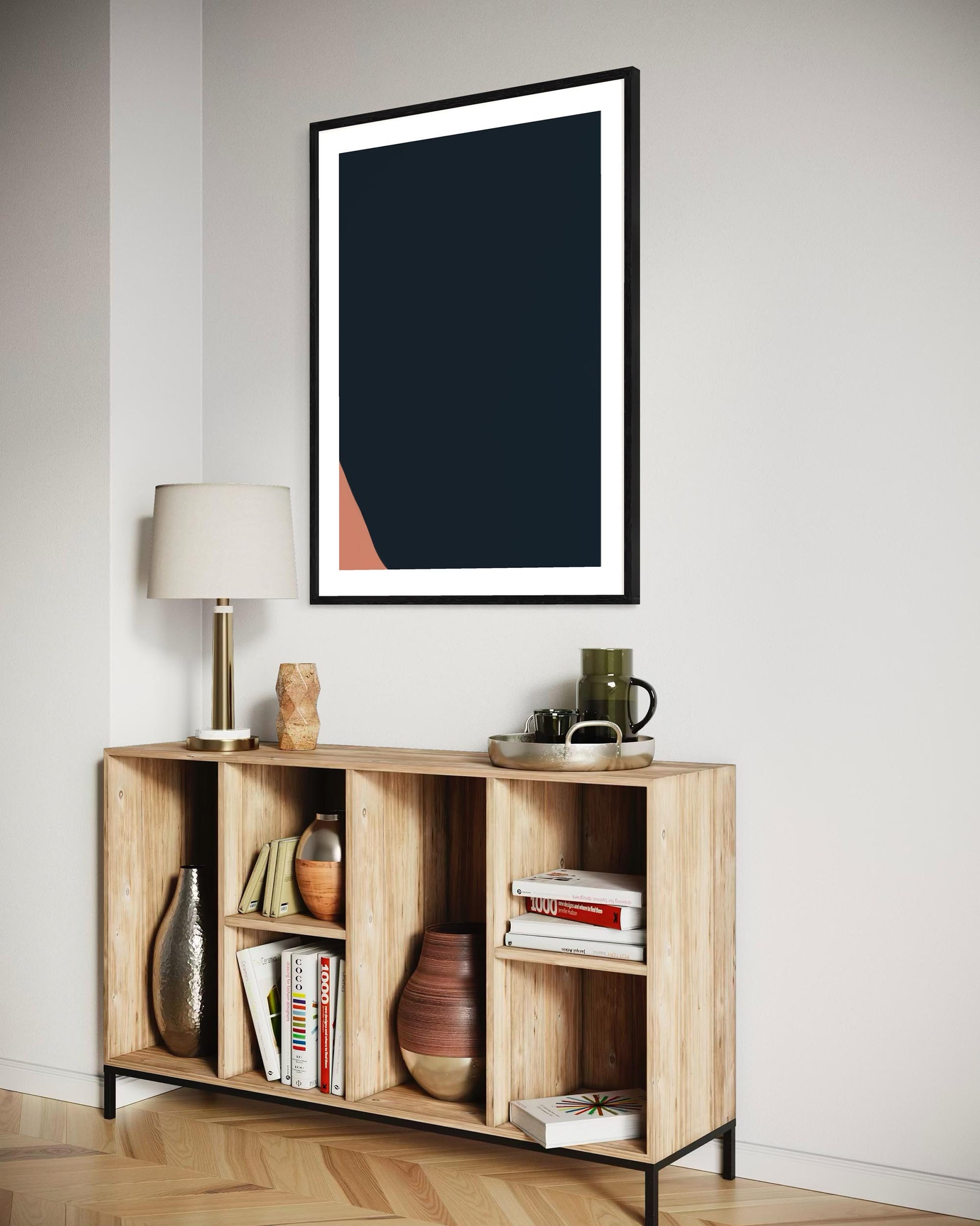 Wooden shelf with decorative items against a white wall with a framed abstract art piece.
