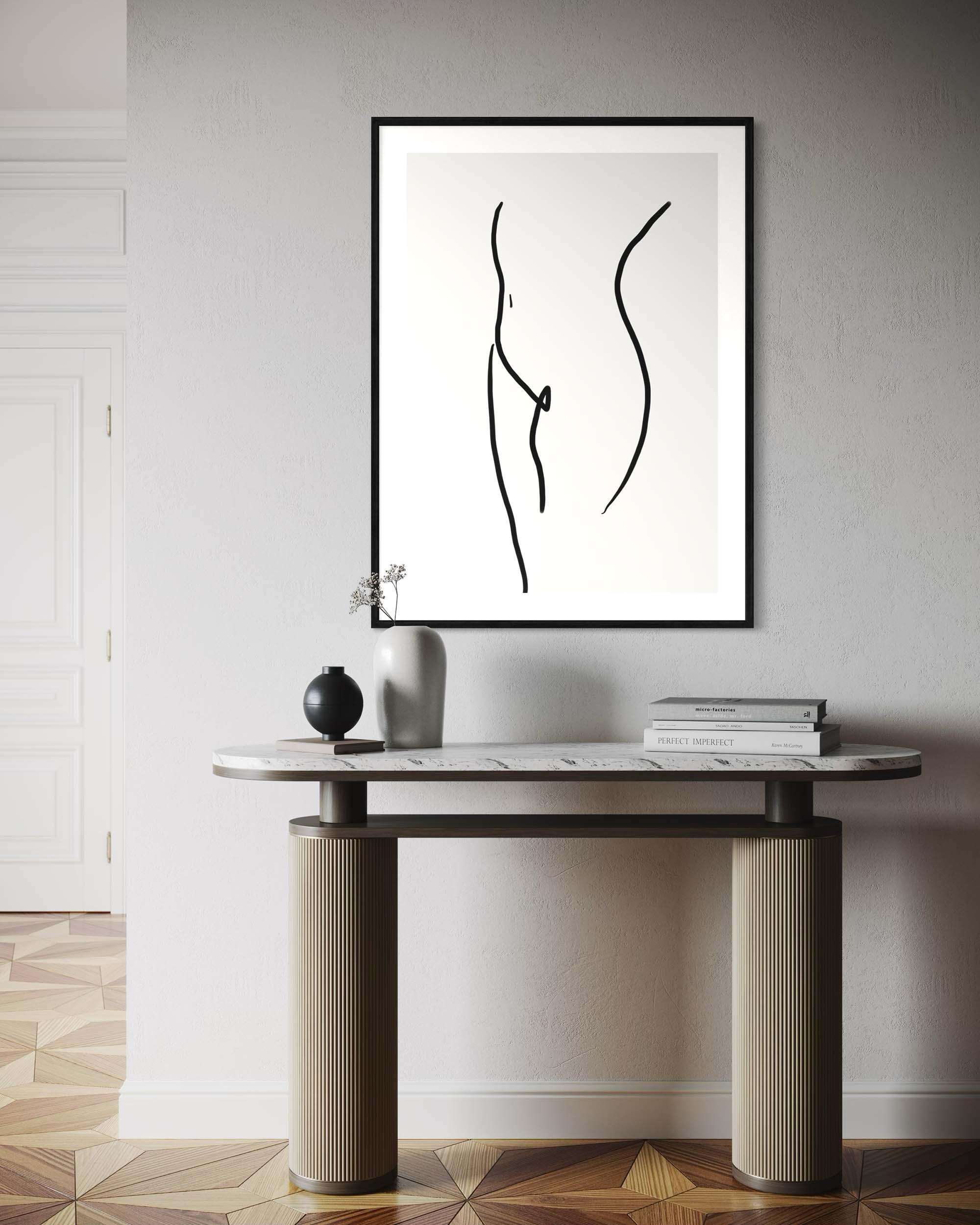 Framed abstract artwork on a wall above a console table with decorative items.