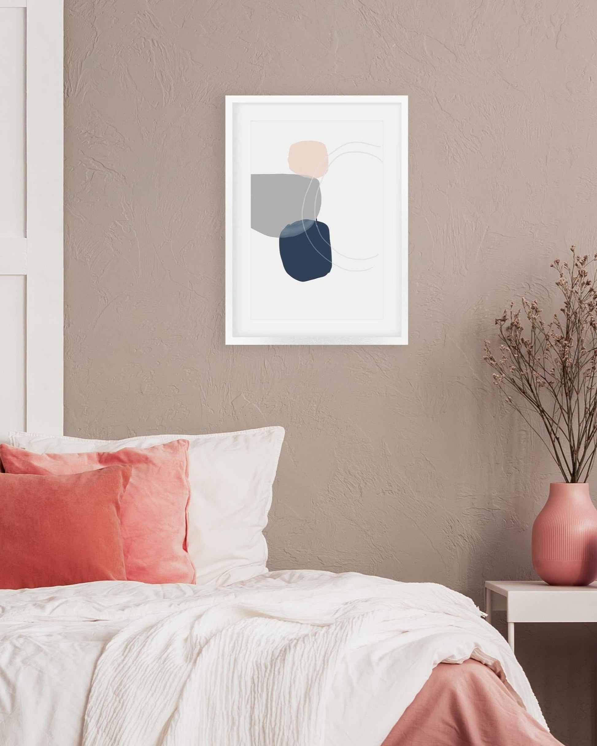 Abstract art print on a wall above a bed with pink and white bedding.