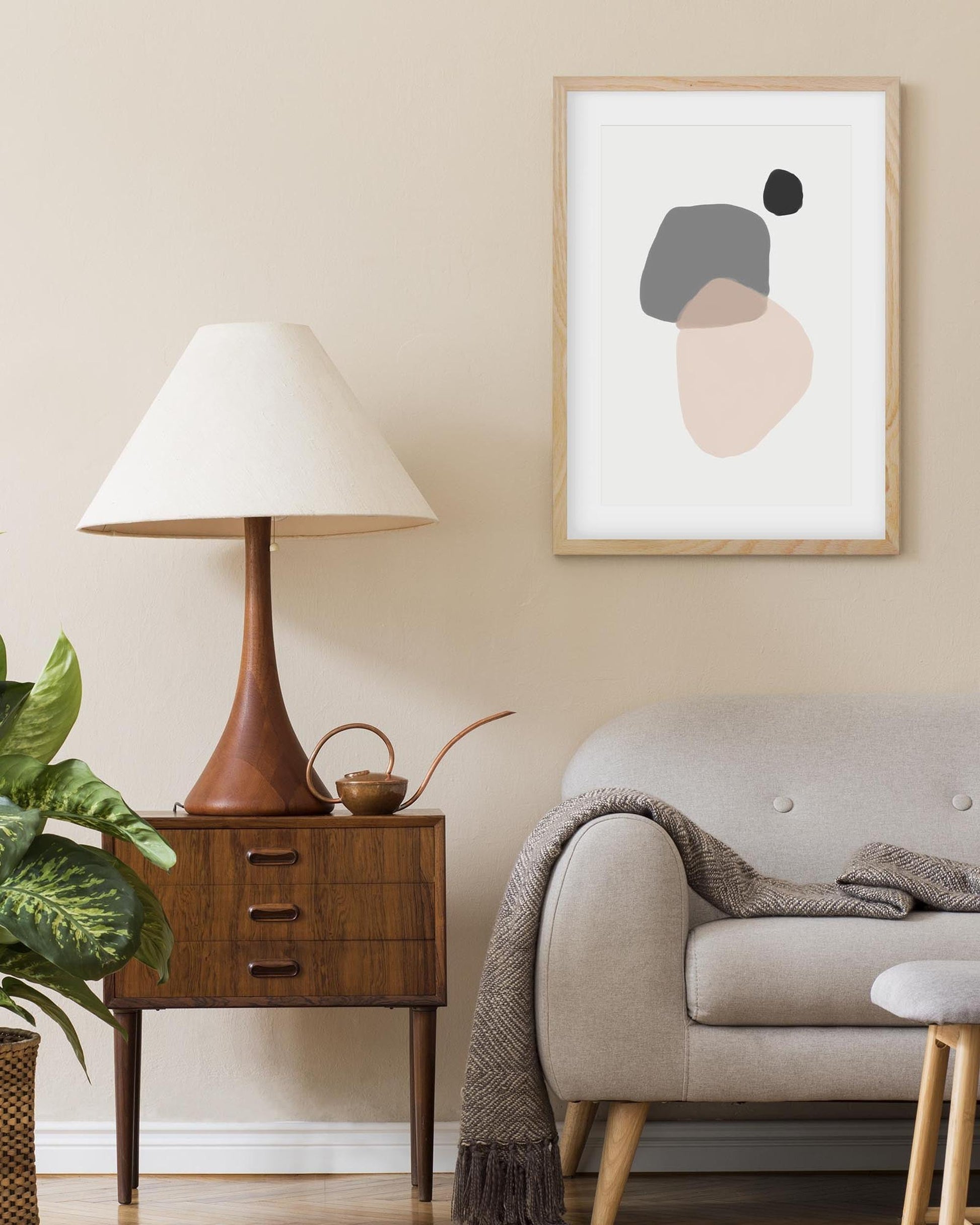 Living room with a lamp, side table, sofa, and abstract art on the wall.